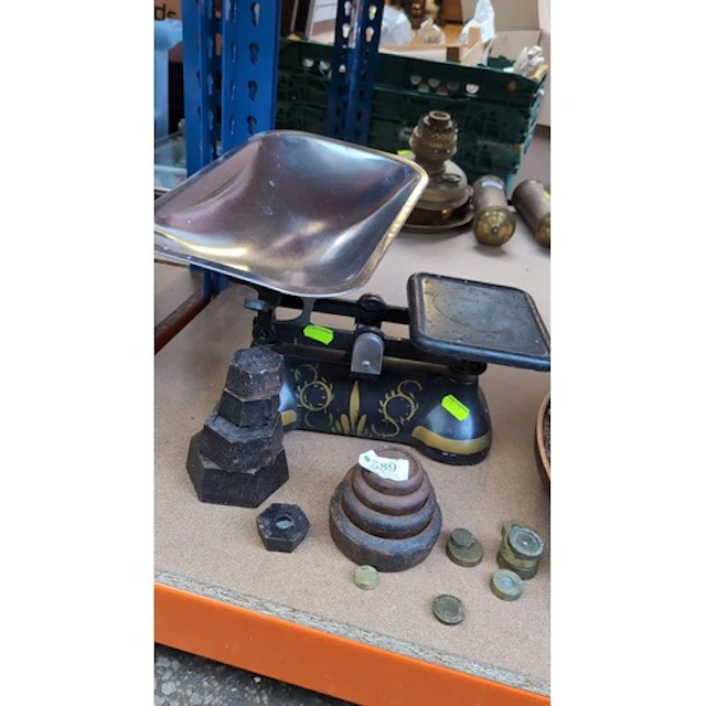 Cast-iron balance scale with a rectangular metal scoop, oppo...