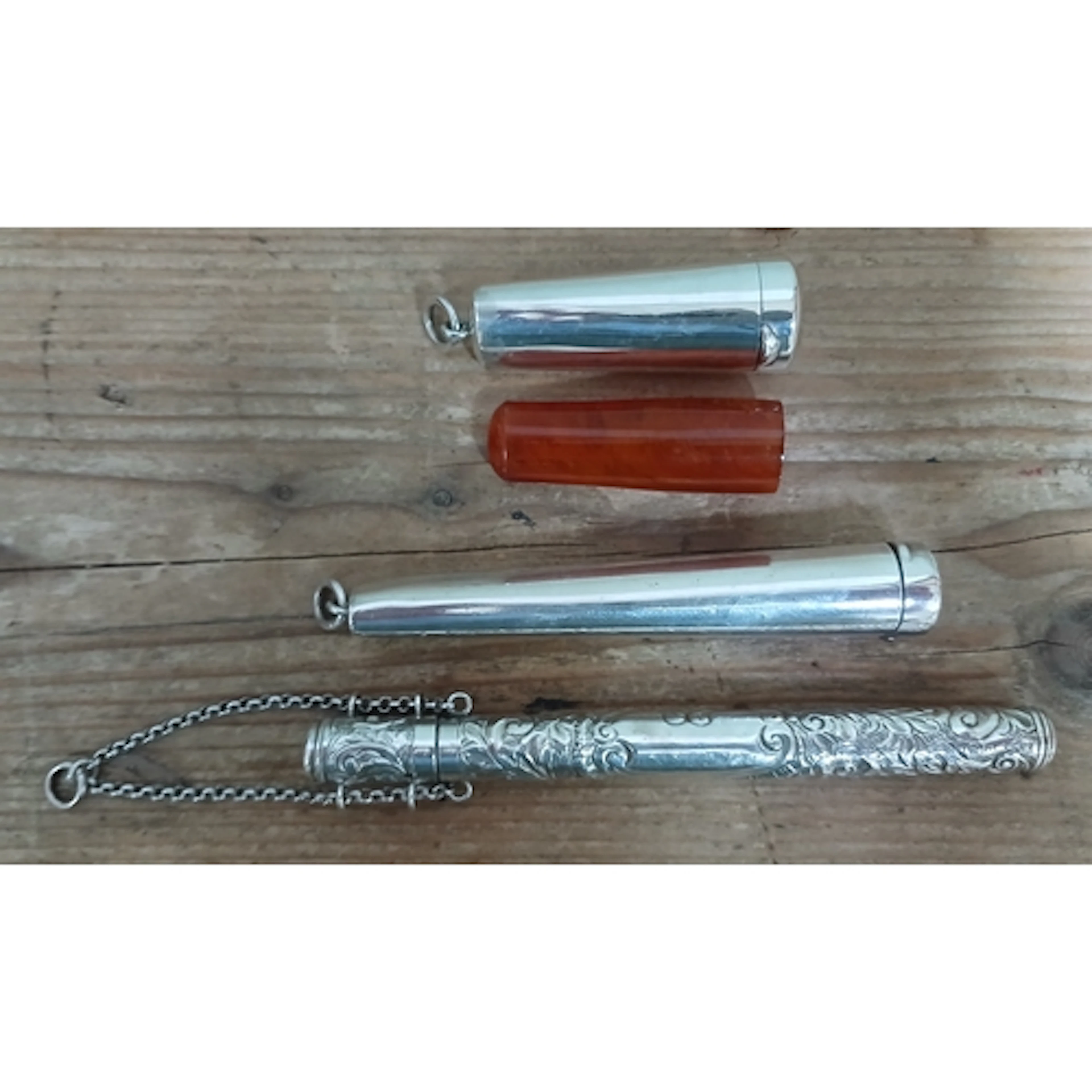 Hallmarked silver comprising two cheroot holders and an embo...