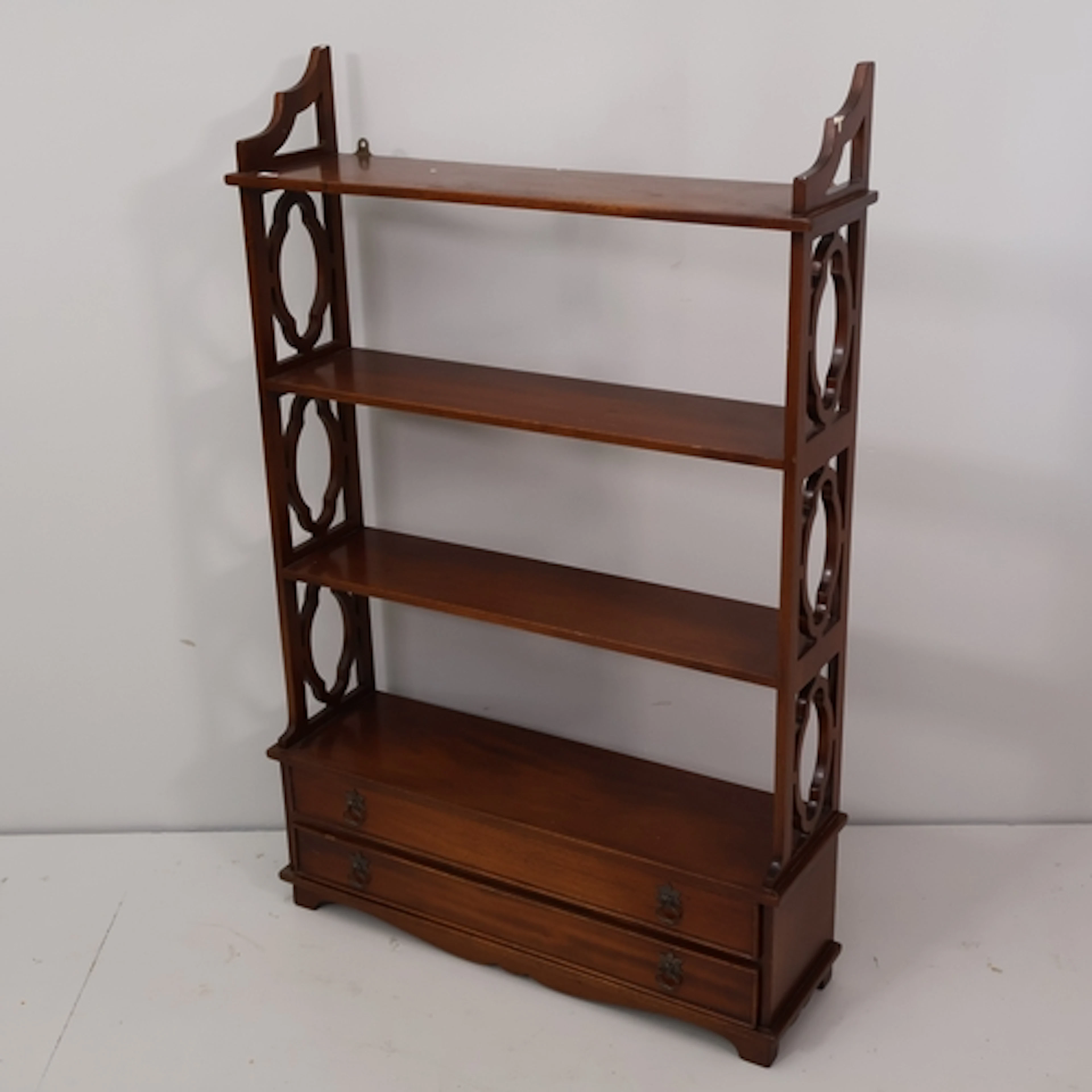 A Chippendale style mahogany open bookcase, with twin drawer...