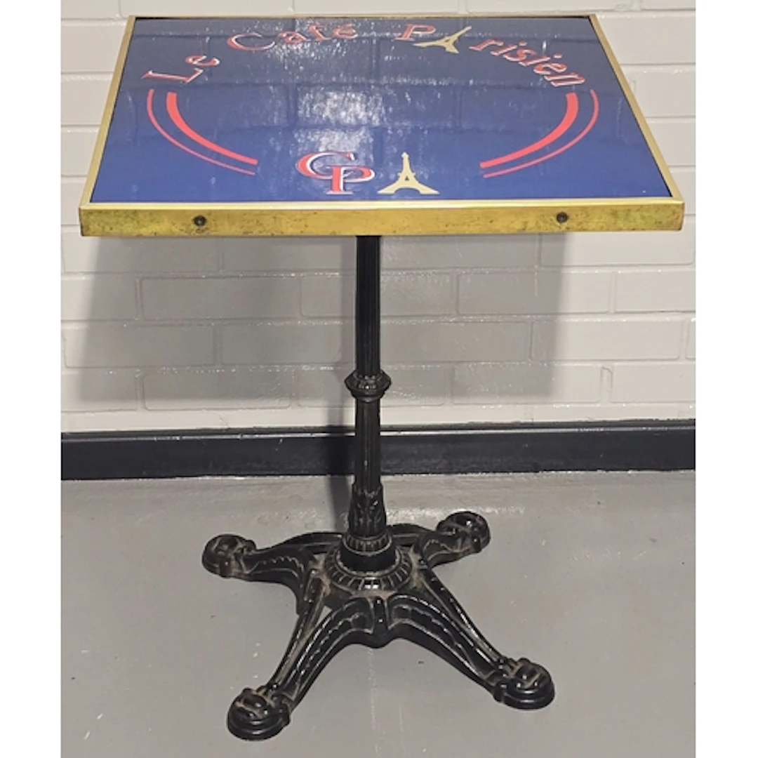 A vintage bistro table resting on heavy antique cast iron ba...