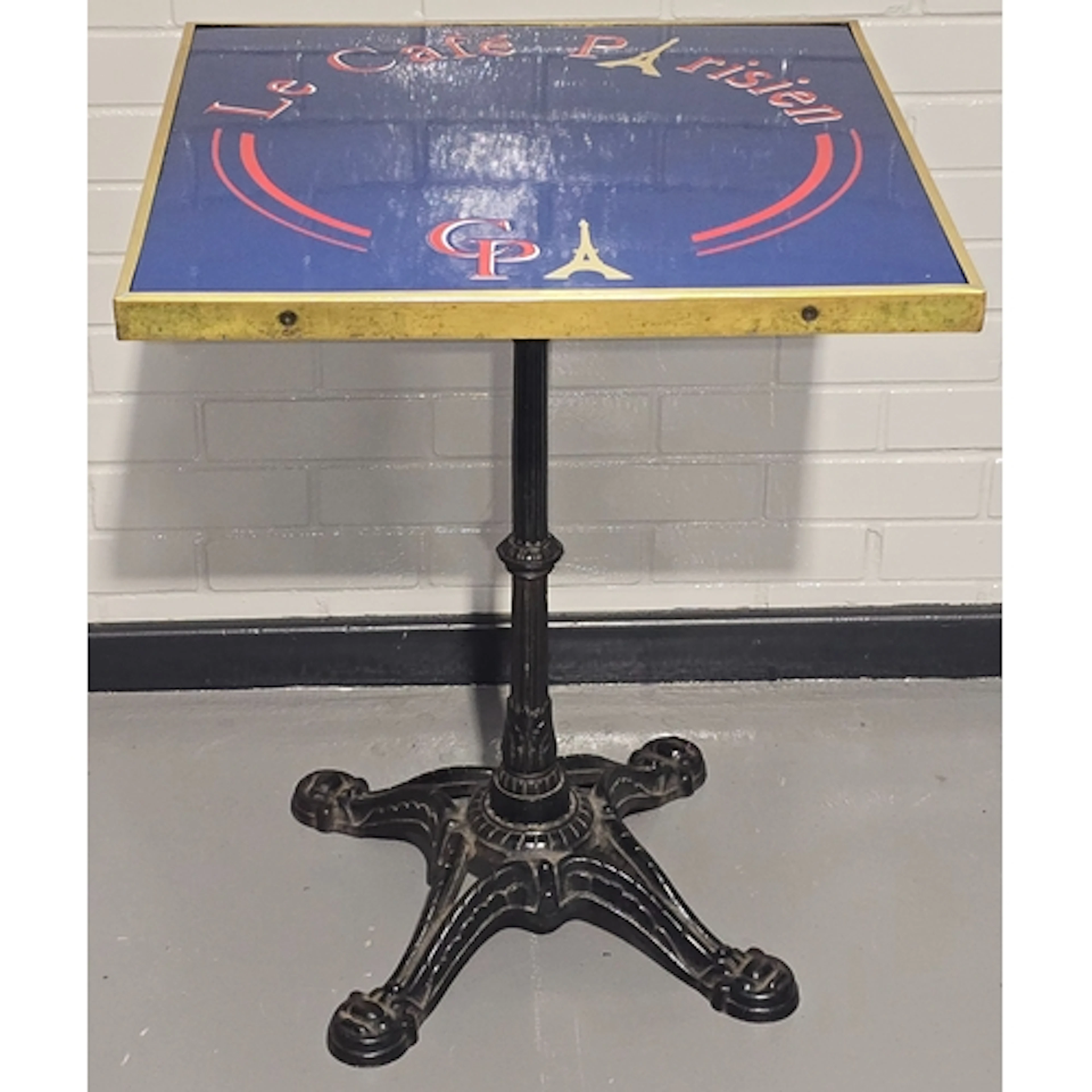 A vintage bistro table resting on heavy antique cast iron ba...