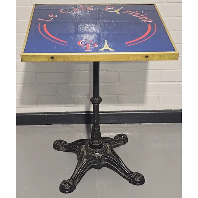 A vintage bistro table resting on heavy antique cast iron ba...