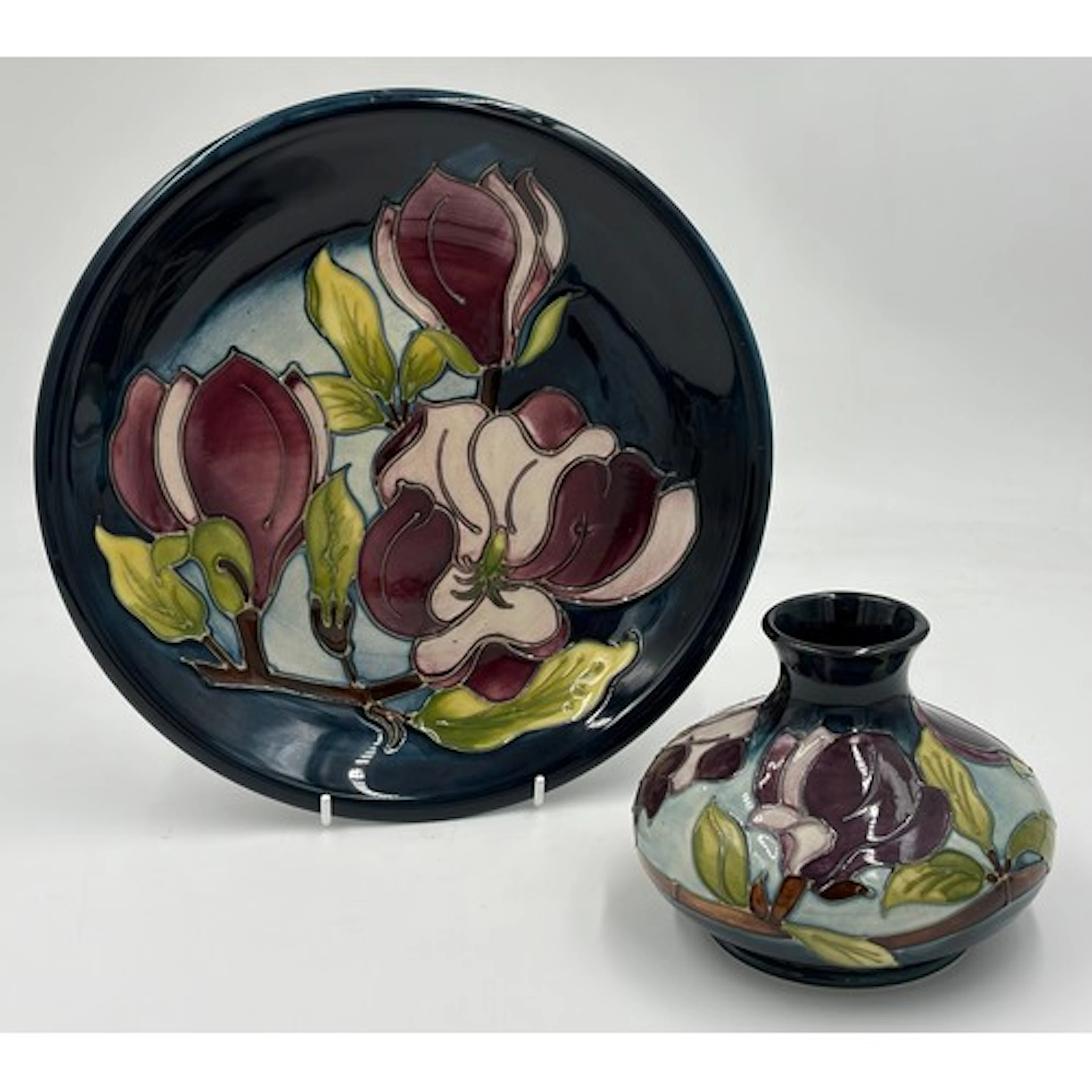Moorcroft 'Magnolia' comprising of a small plate 26cm d and...