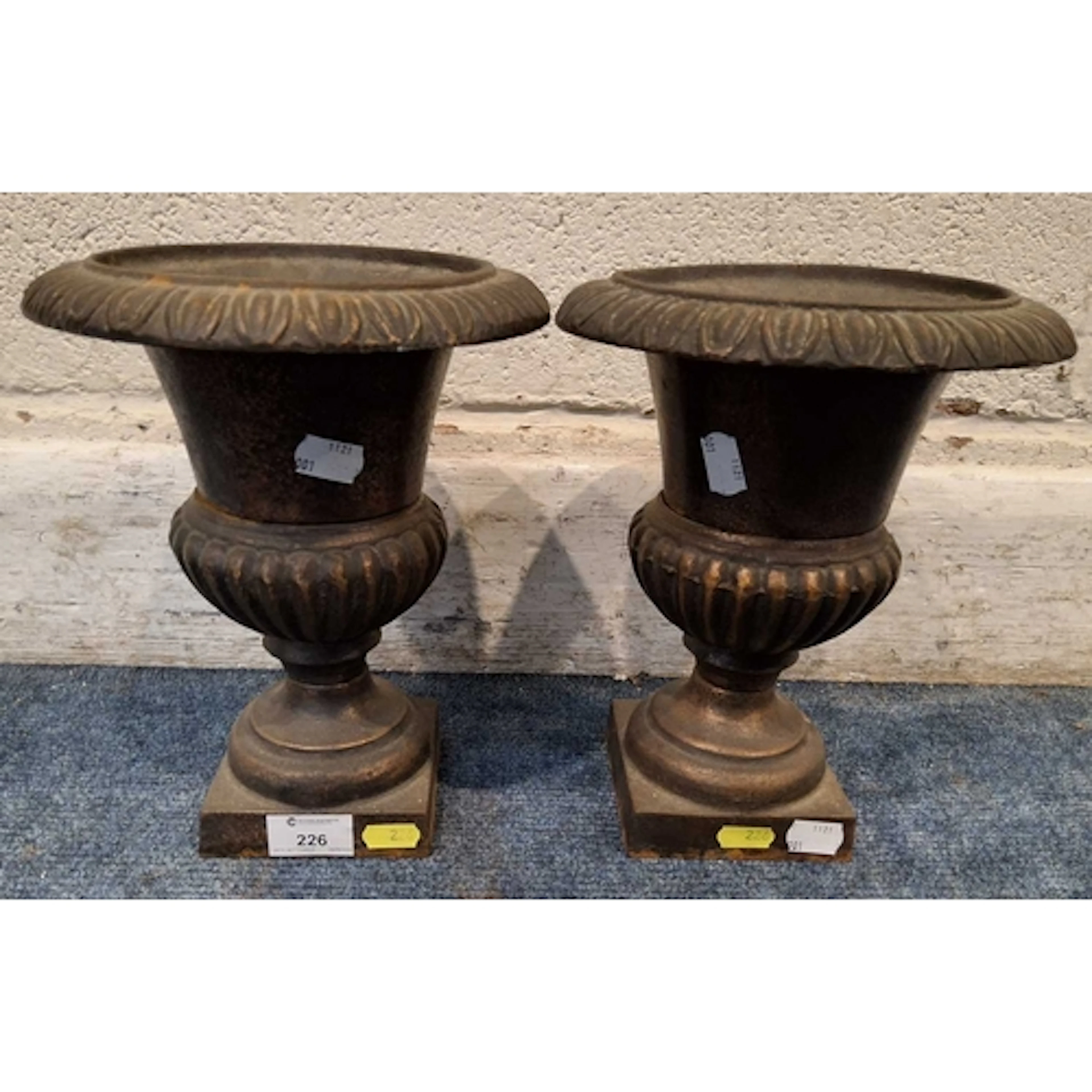 A PAIR OF SMALL CAST IRON CAMPANA URNS, with an egg and dart...