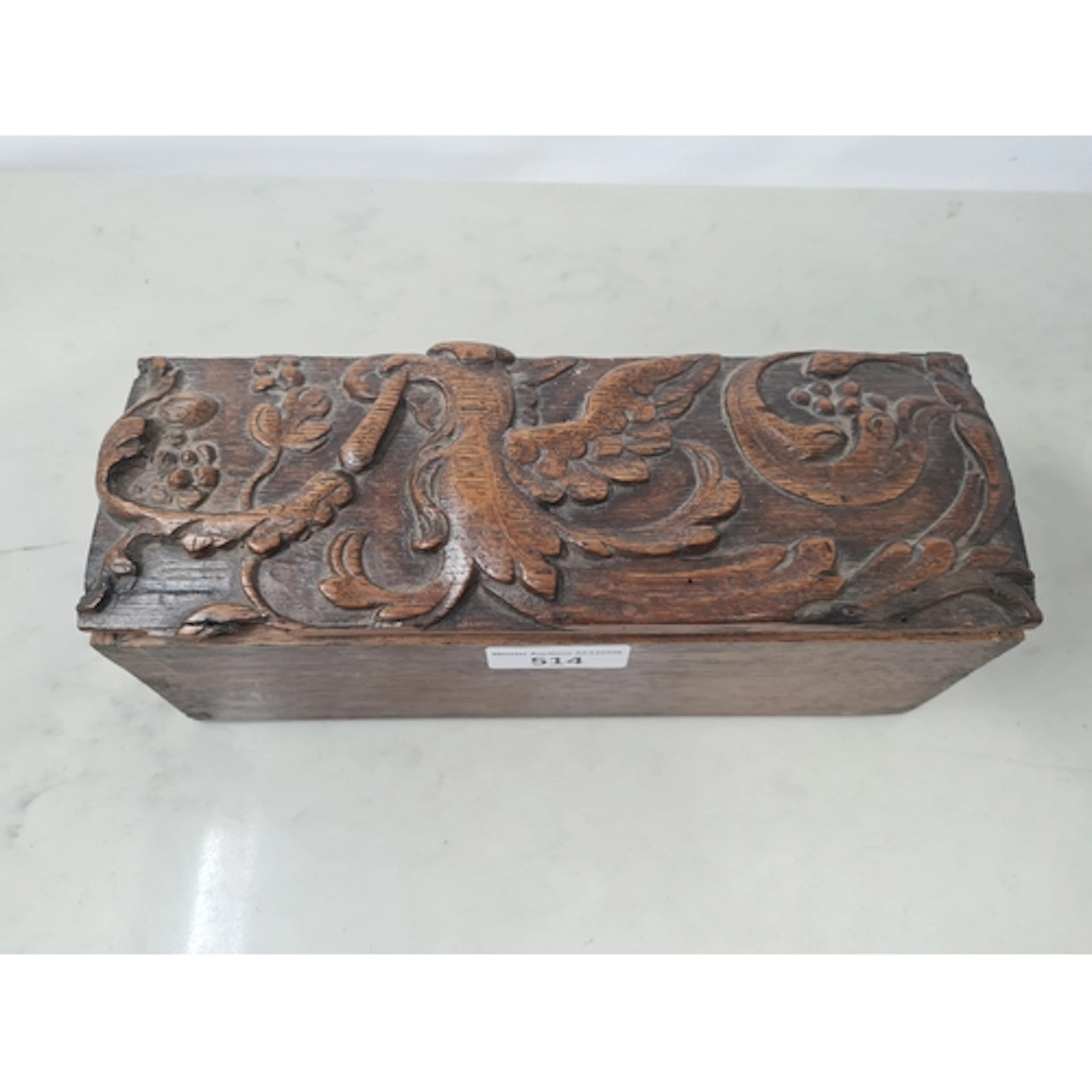 An antique oak Box with hinged lid carved griffon and fruiti...