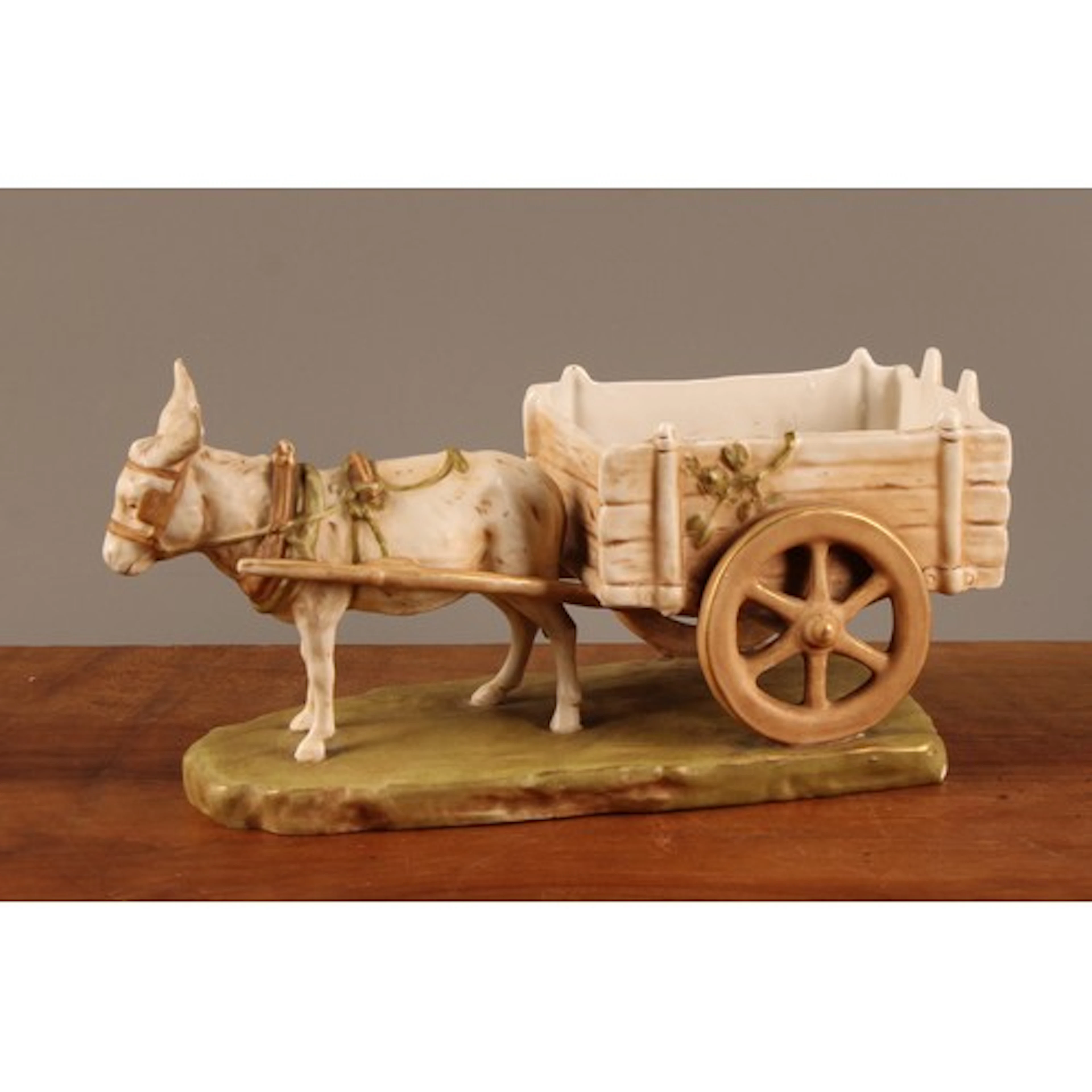 A Royal Dux group of a donkey pulling a cart, coloured in to...