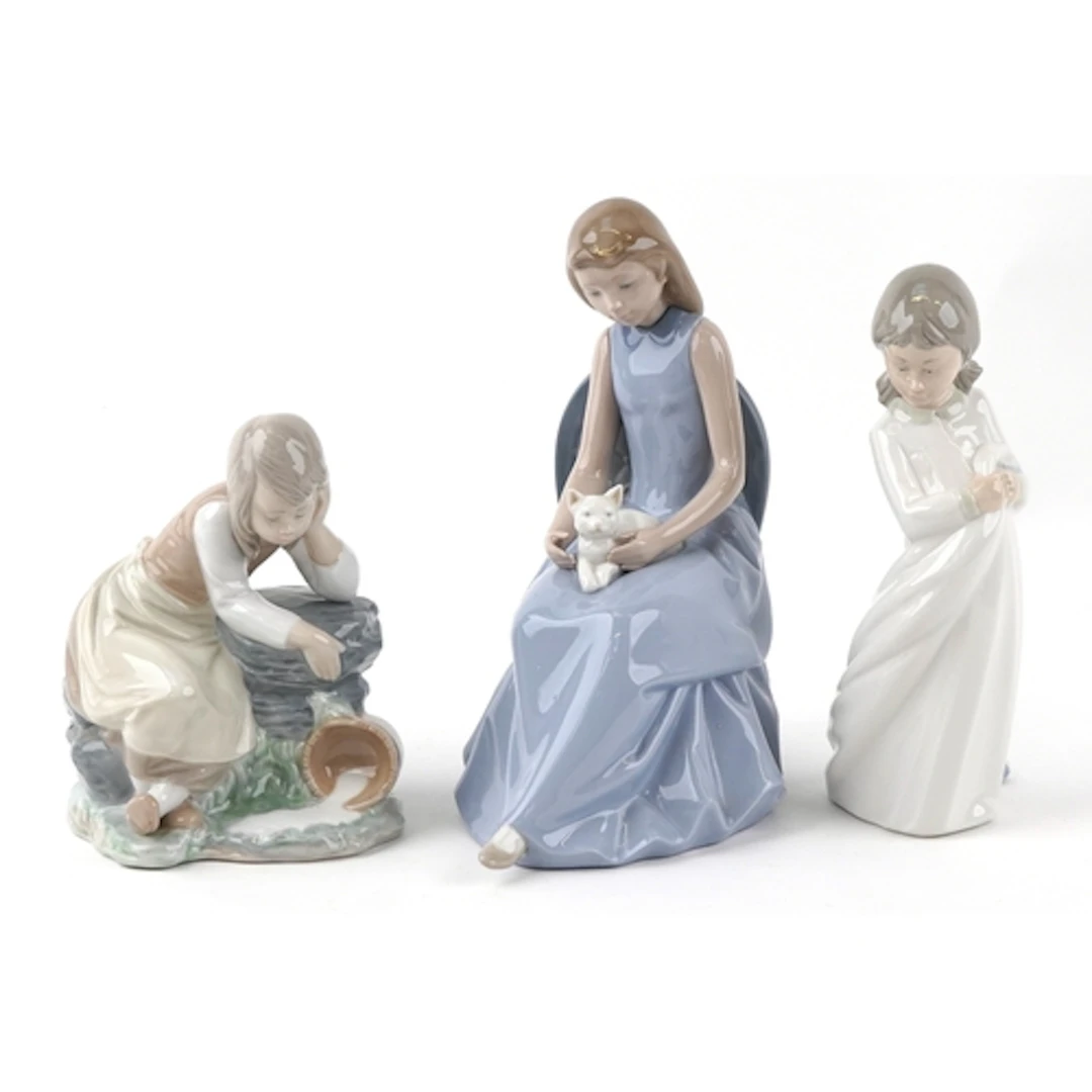 Three Nao porcelain figures including female with a cat, the...