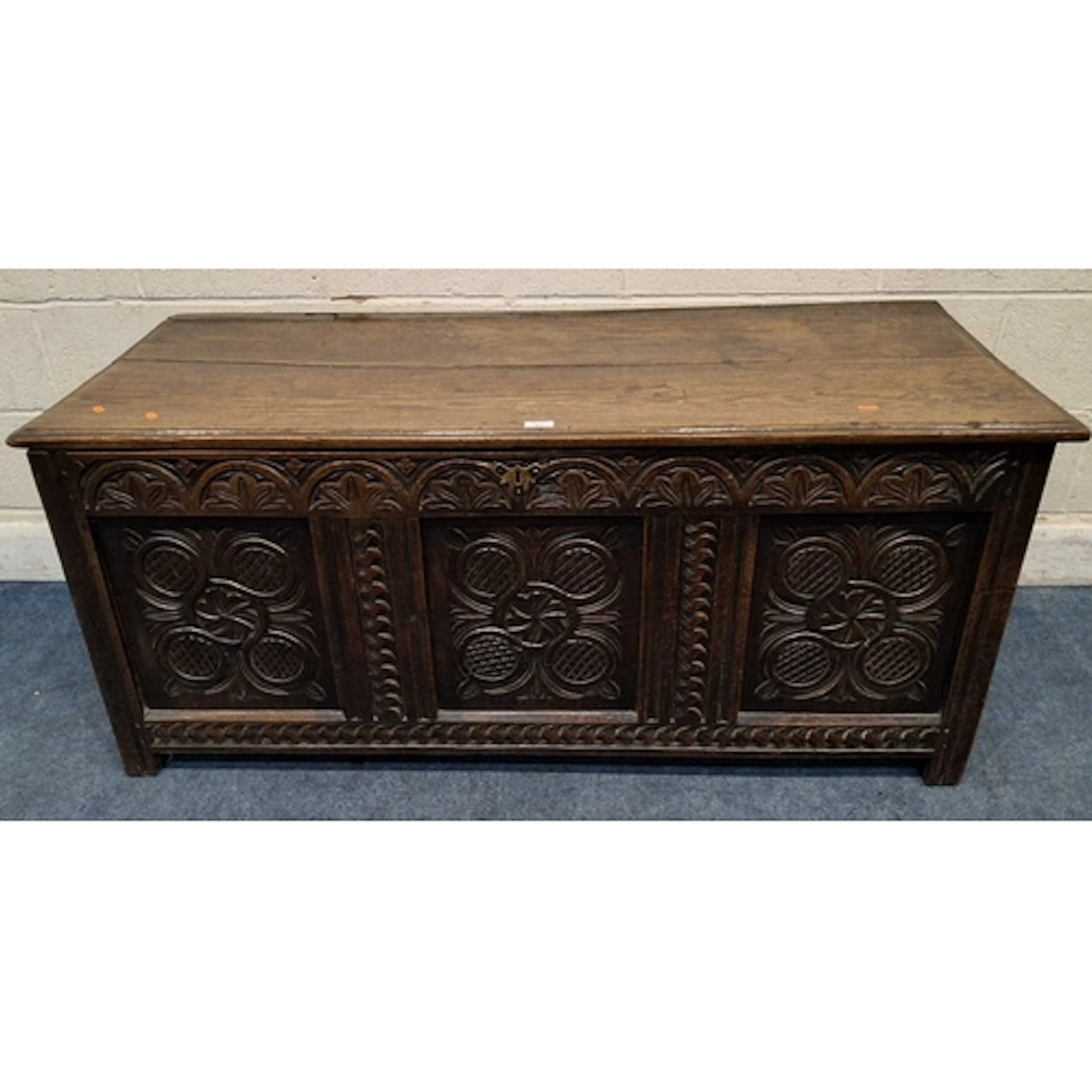 A GEORGIAN OAK COFFER, with a hinged lid, with repeating car...