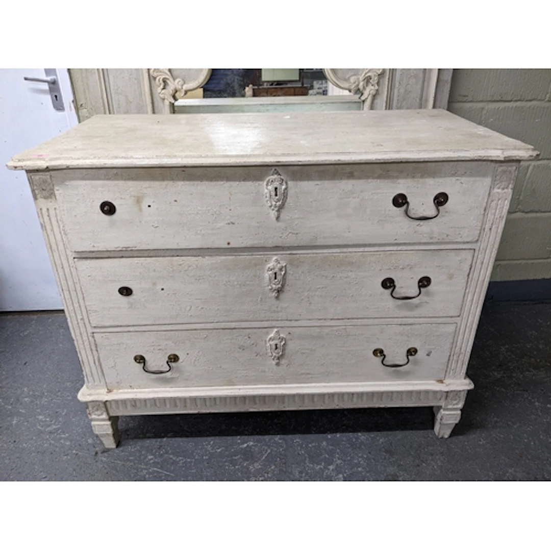 A cream painted chest of three drawers with brass swan neck ...