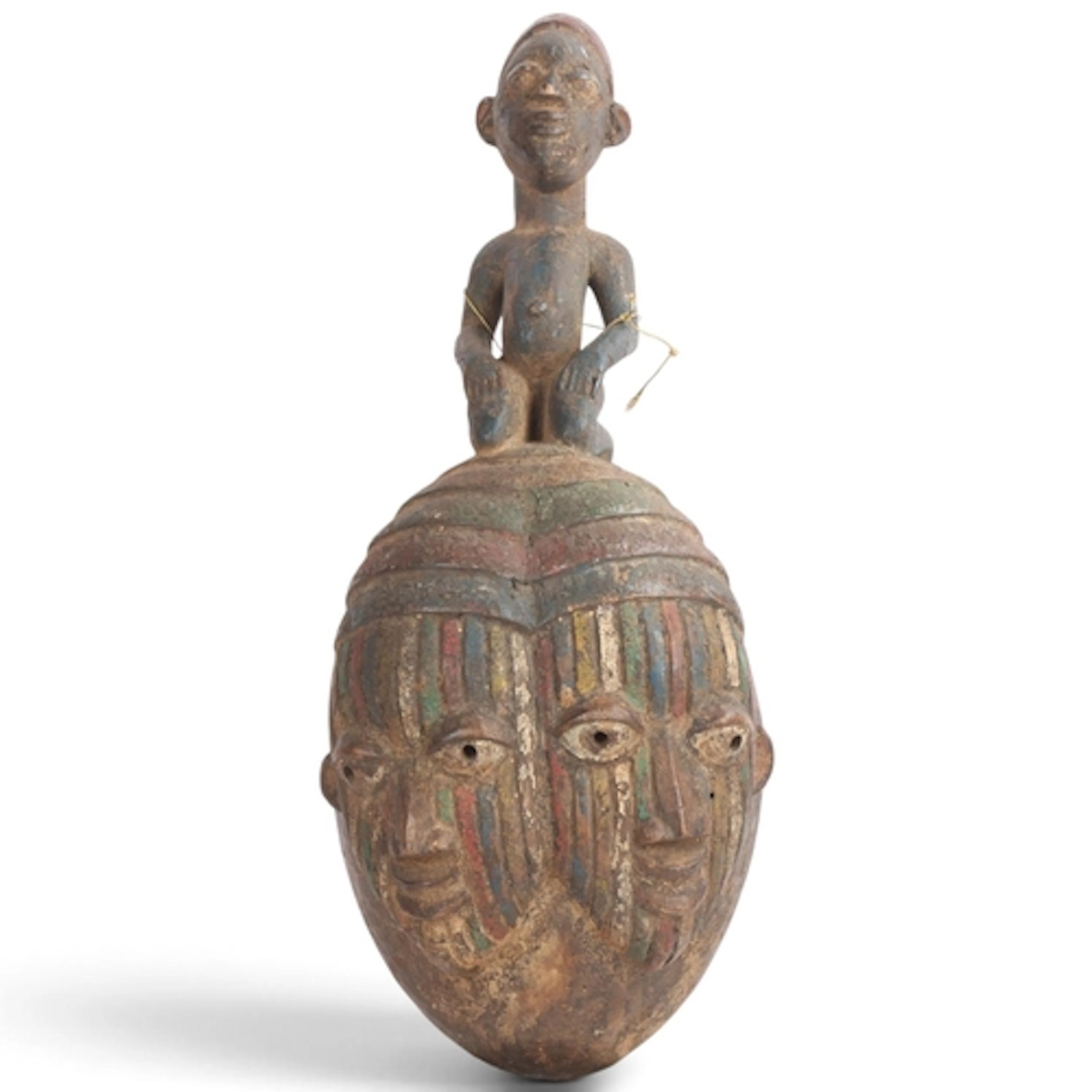 A Yoruba double-faced mask surmounted by a kneeling figure, ...