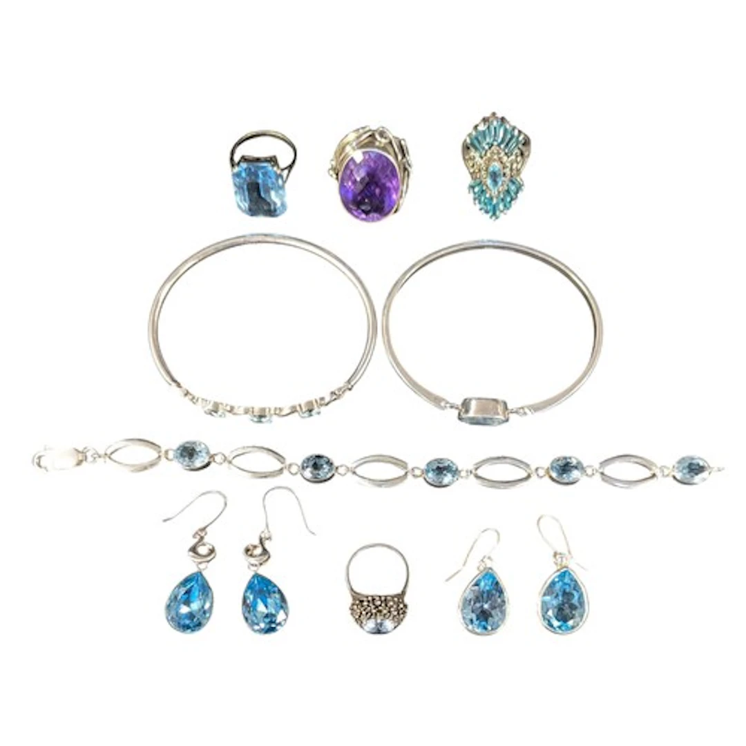 A silver and pale blue topaz spring action bangle, another t...