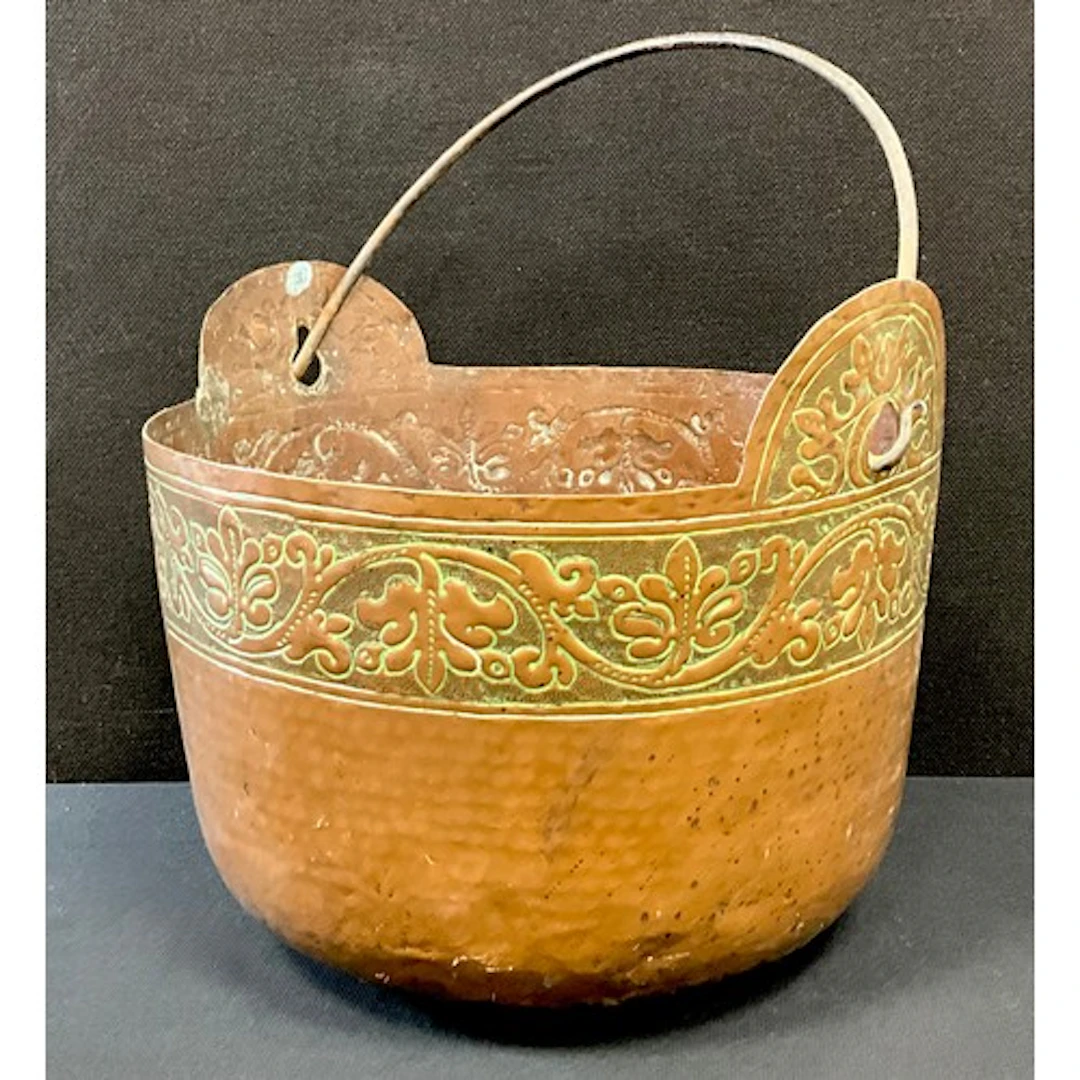 An Arts & Crafts copper fuel bucket, decorated with a repous...