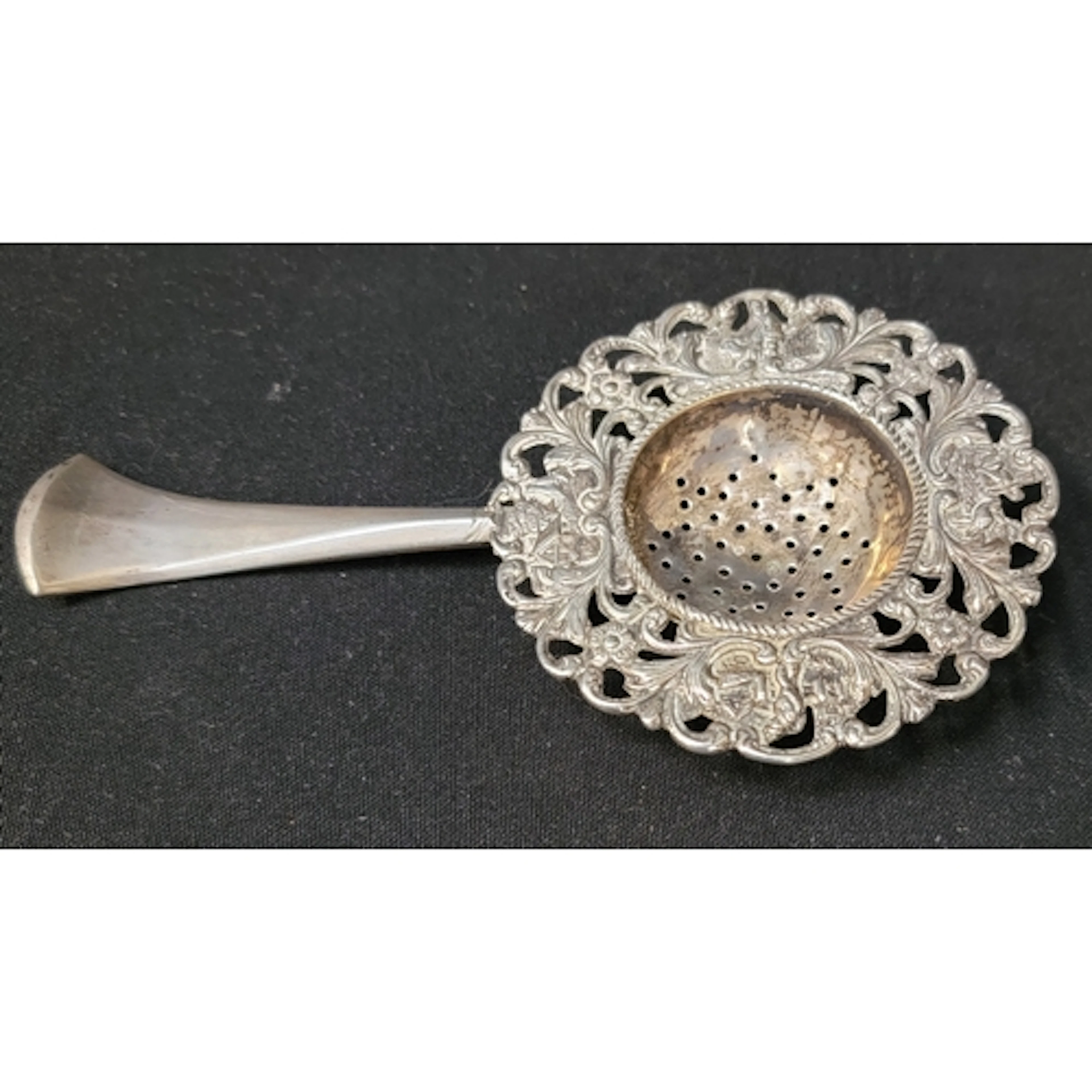 UNMARKED SILVER TEA STRAINER with pierced circular bowl, de...