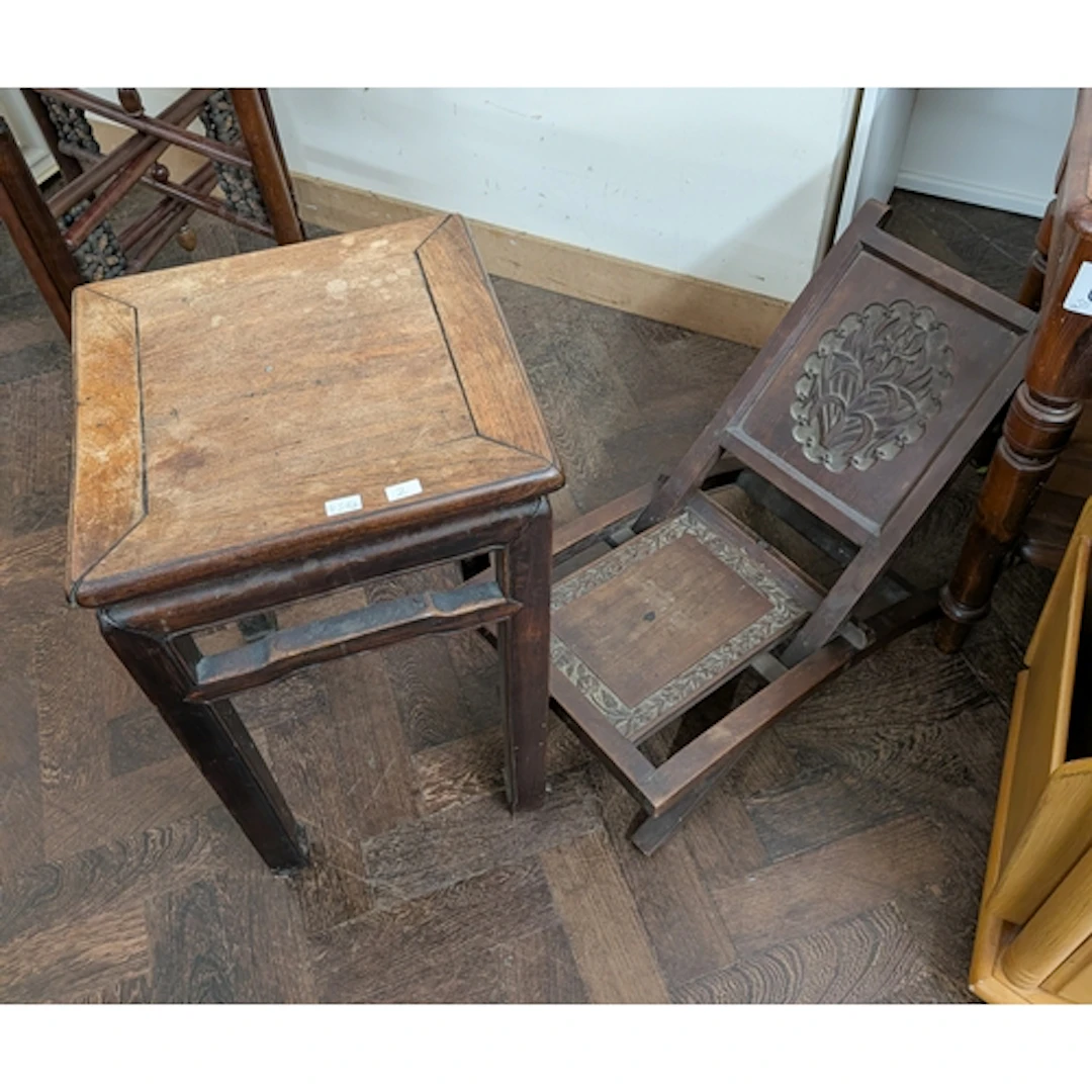 A Chinese hardwood plant table or stool and a carved folding...