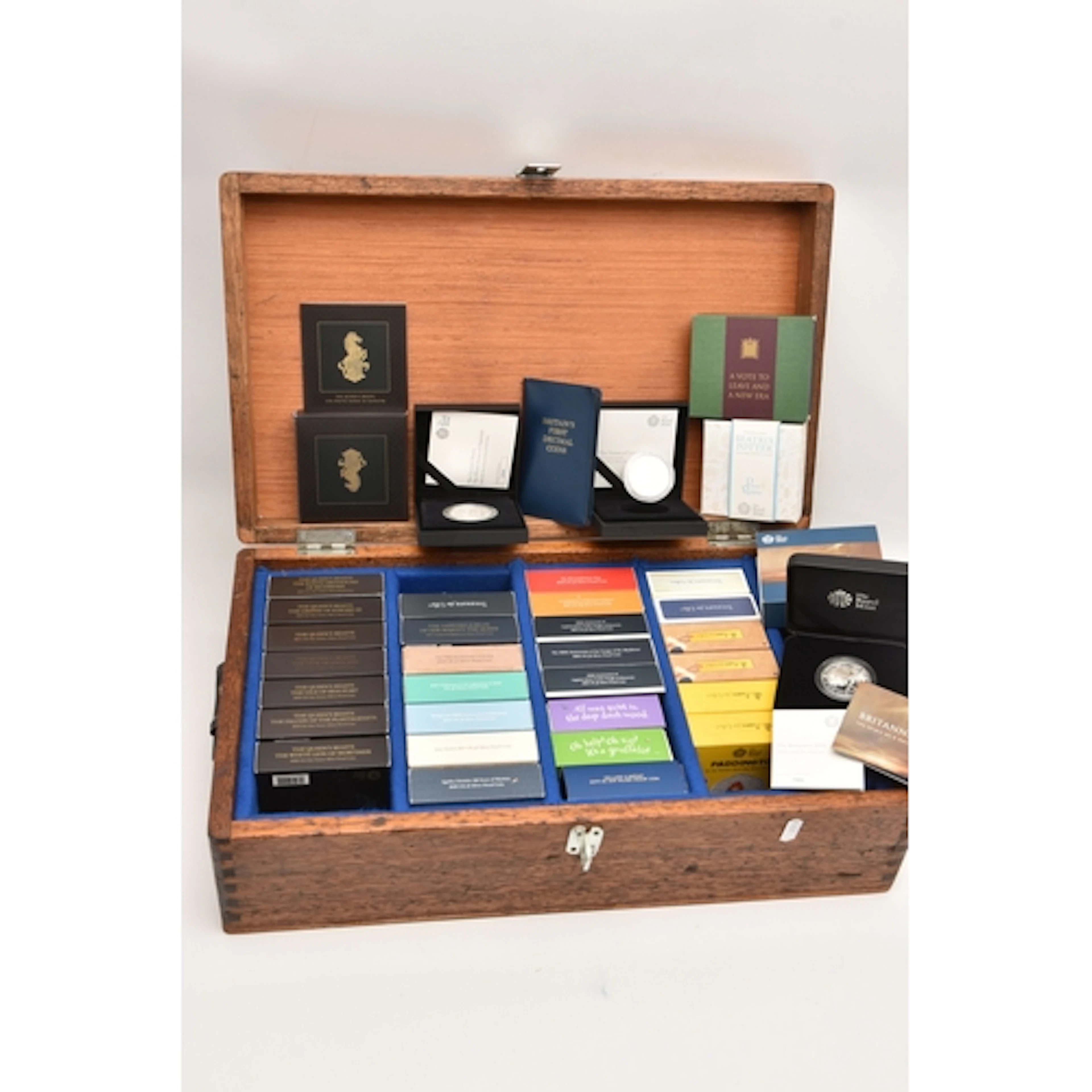 A LARGE AND HEAVY WOODEN TRUNK CONTAINING 33 x ROYAL MINT BO...