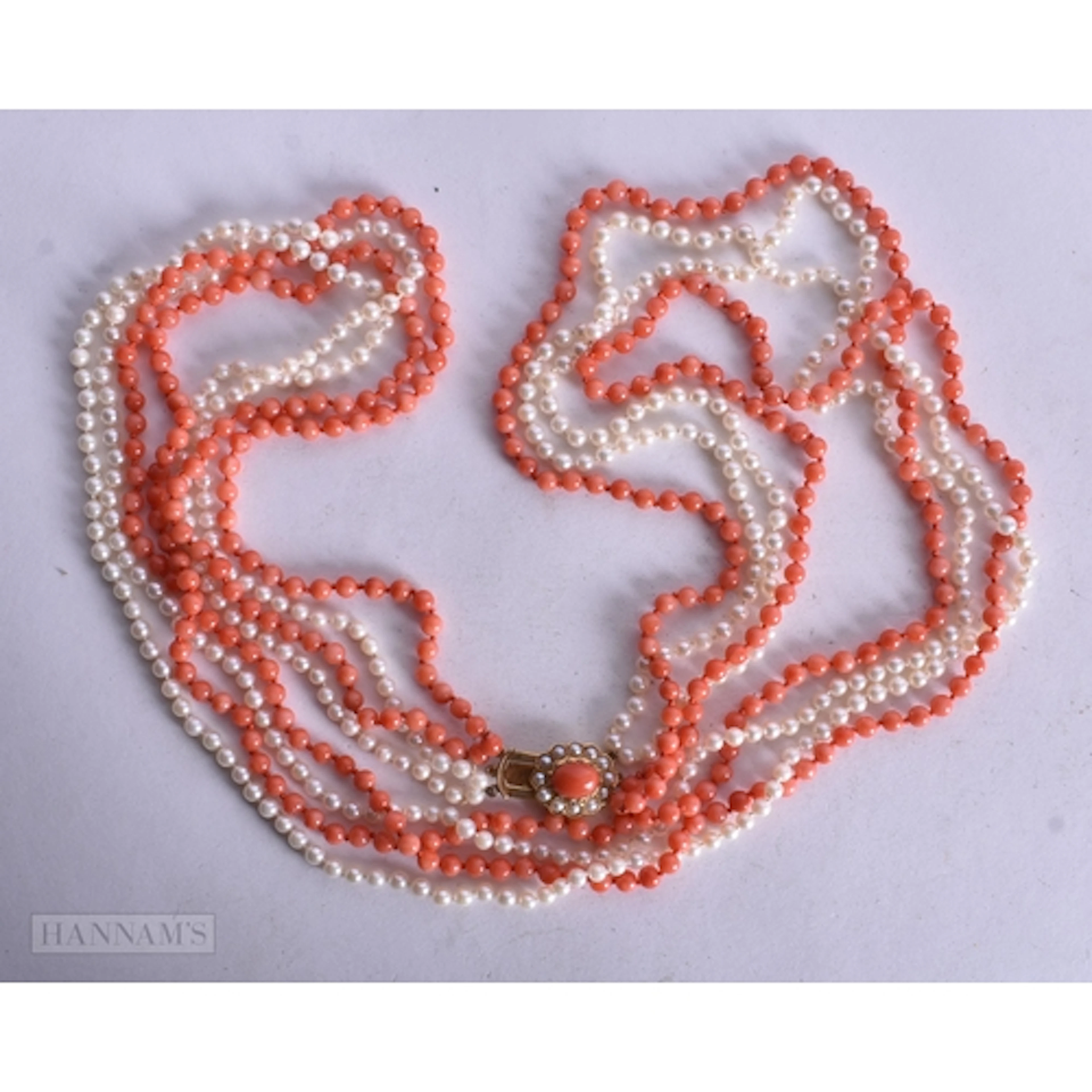A LONG 9CT GOLD PEARL AND CORAL FOUR STRAND NECKLACE. 69.1 g...