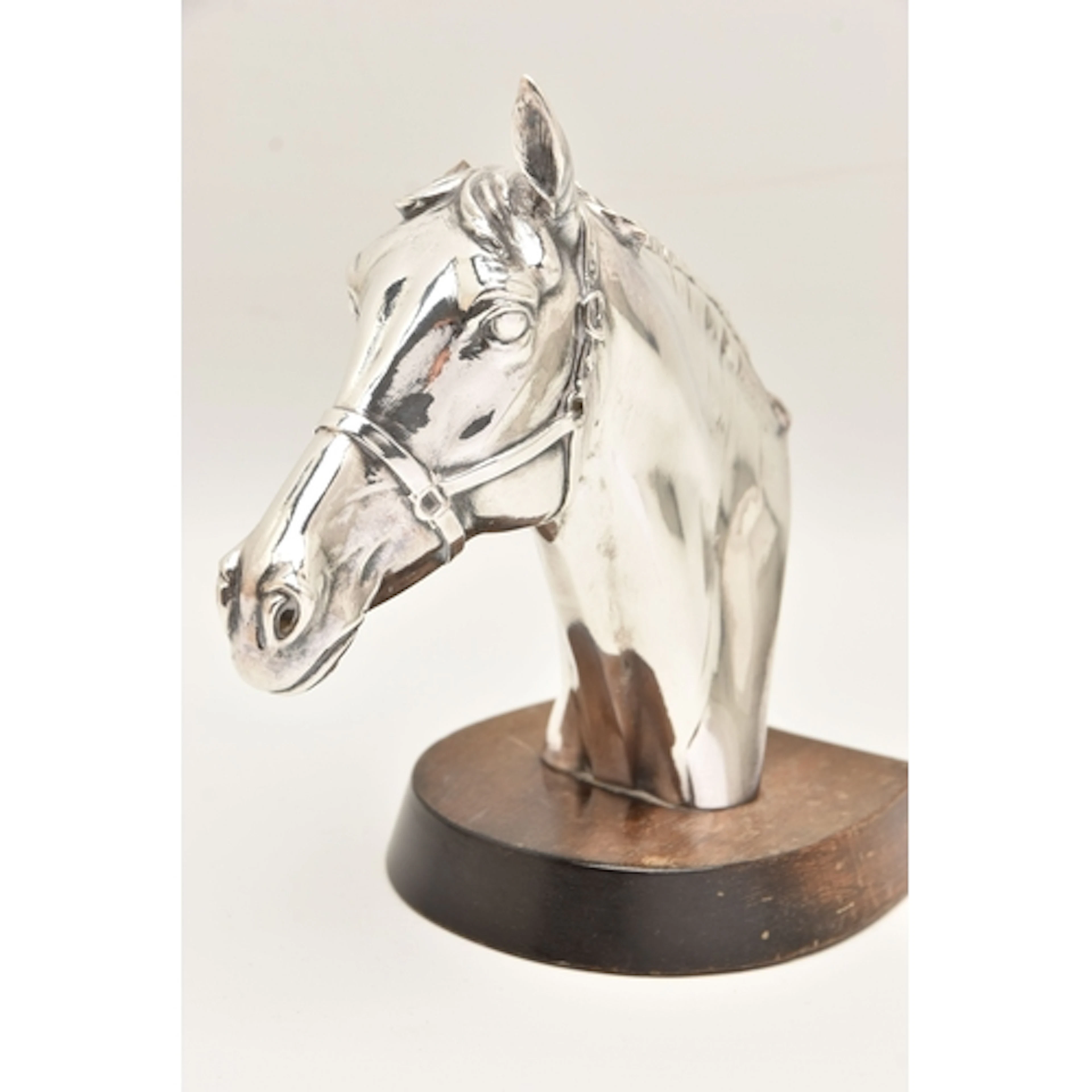 A MOUNTED FILLED SILVER HORSE HEAD, fitted on a wooden base,...