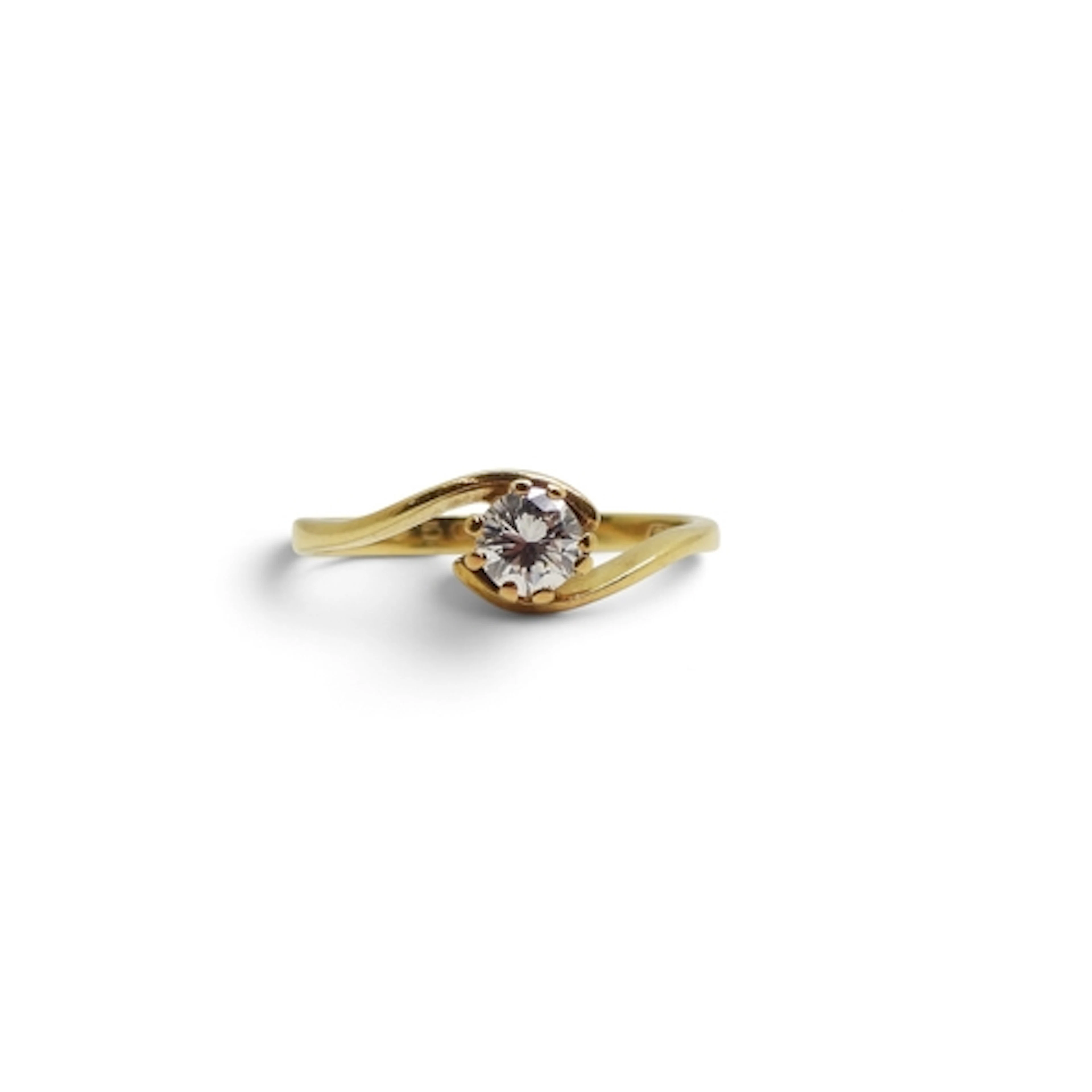 An 18ct gold solitaire ring on a twist, set with a 0.33ct di...