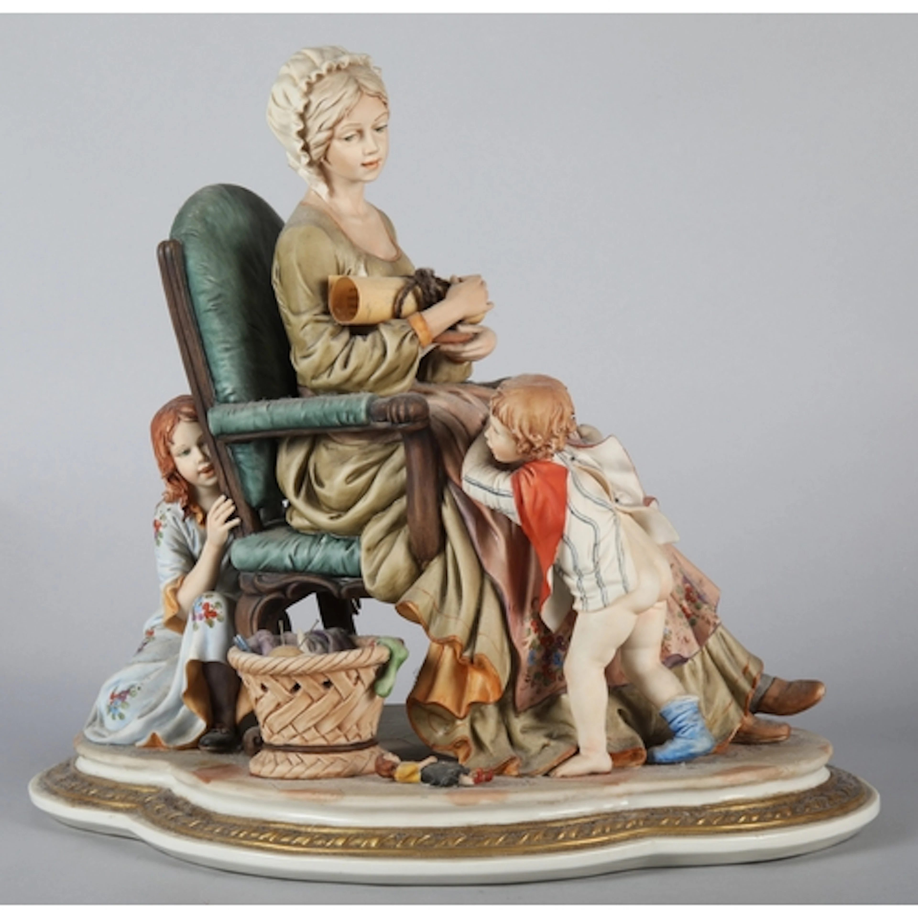 Capodimonte group figurine of a seated mother with young chi...