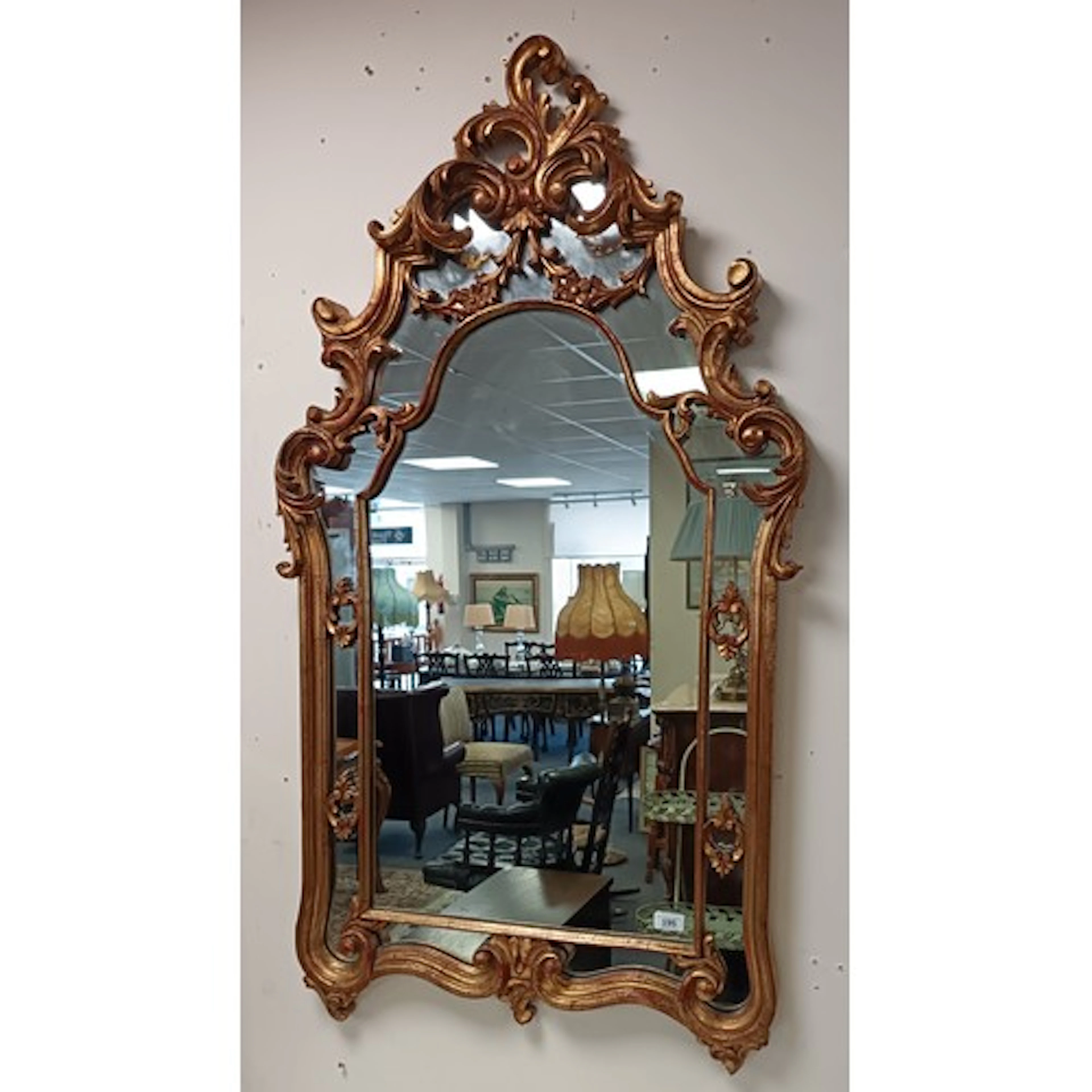 Ornate gilt -effect wall mirror with elaborate scrollwork fr...