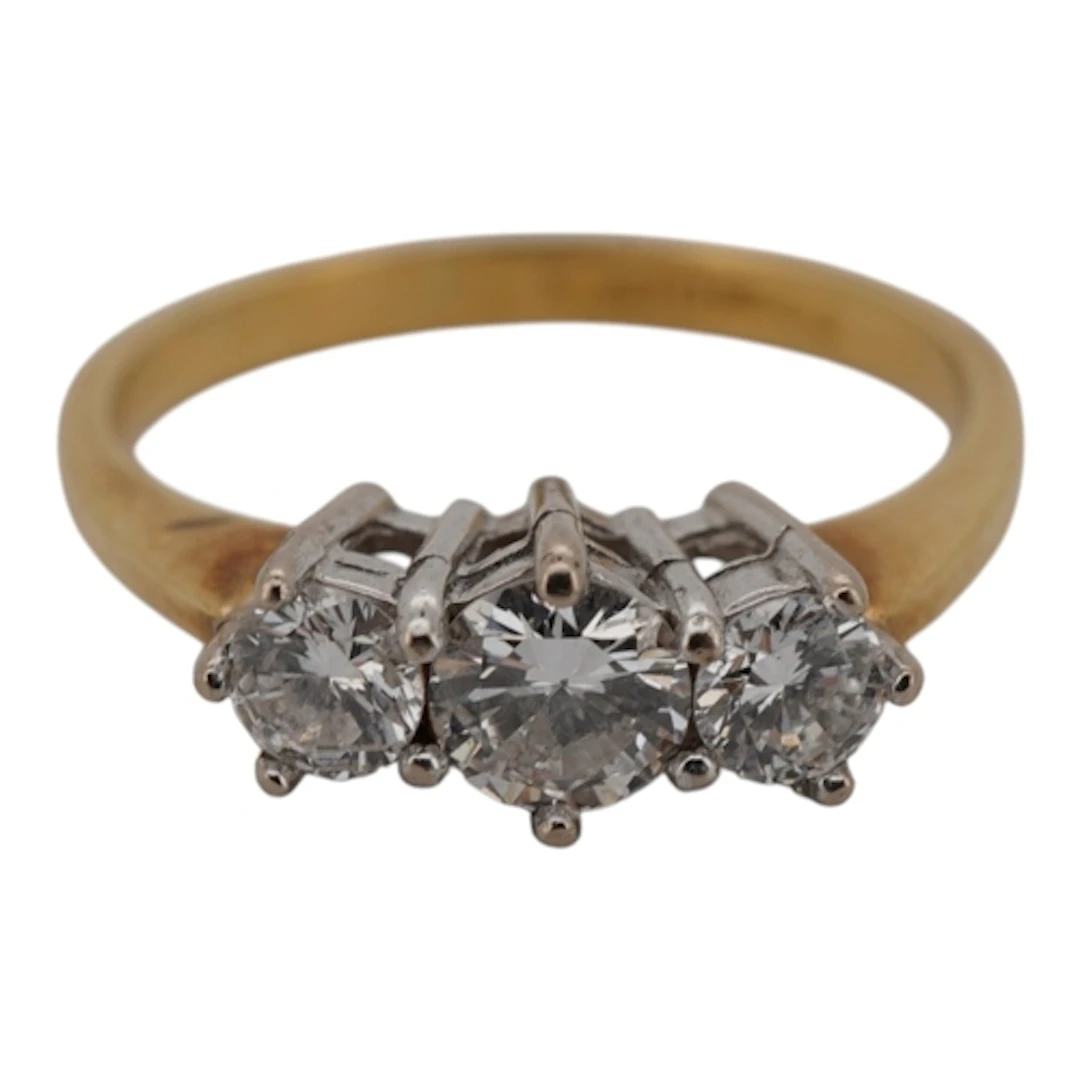 A three-stone diamond ring, claw-set with three brilliant-cu...