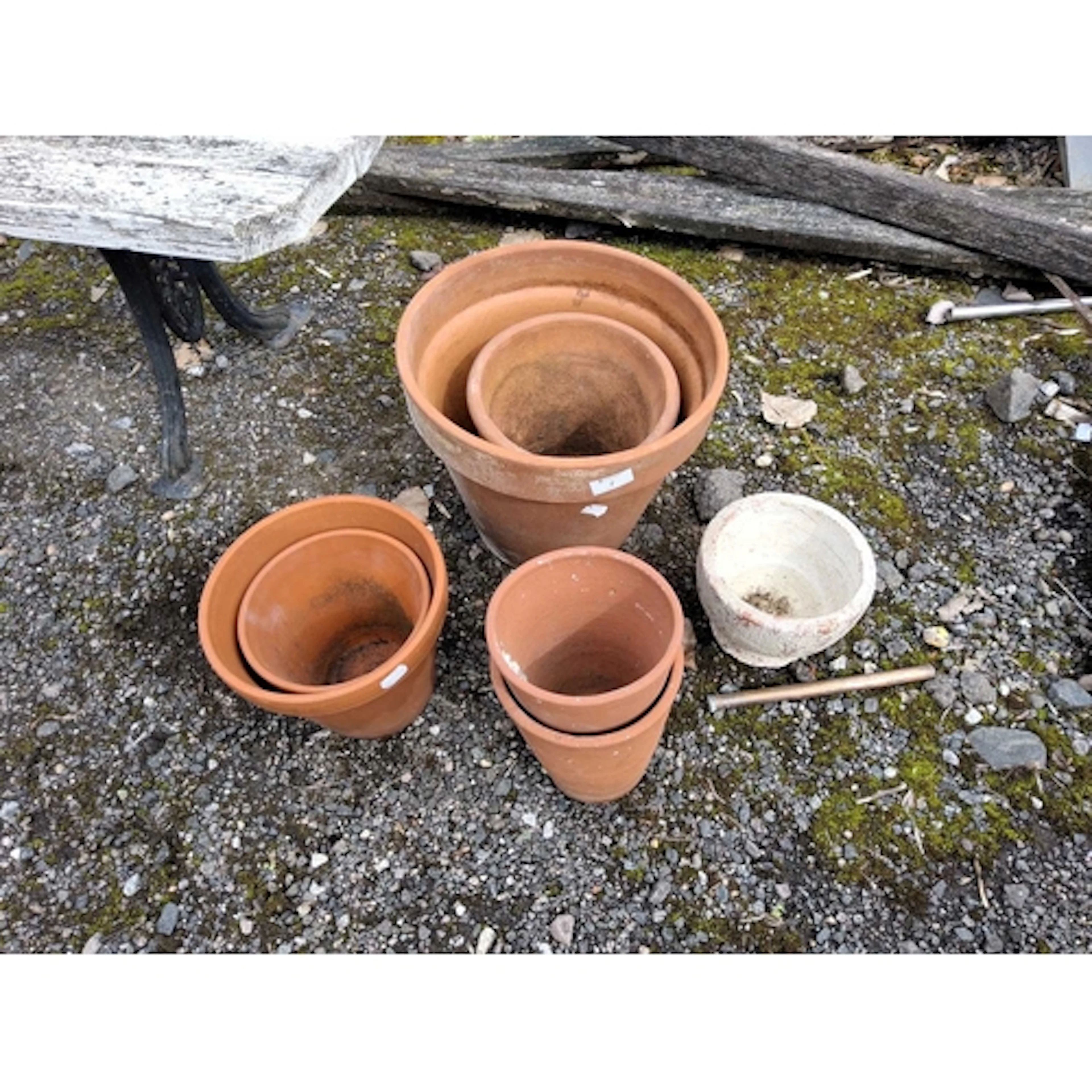 SEVEN TERRACOTTA PLANT POTS, the largest being 31cm in diame...