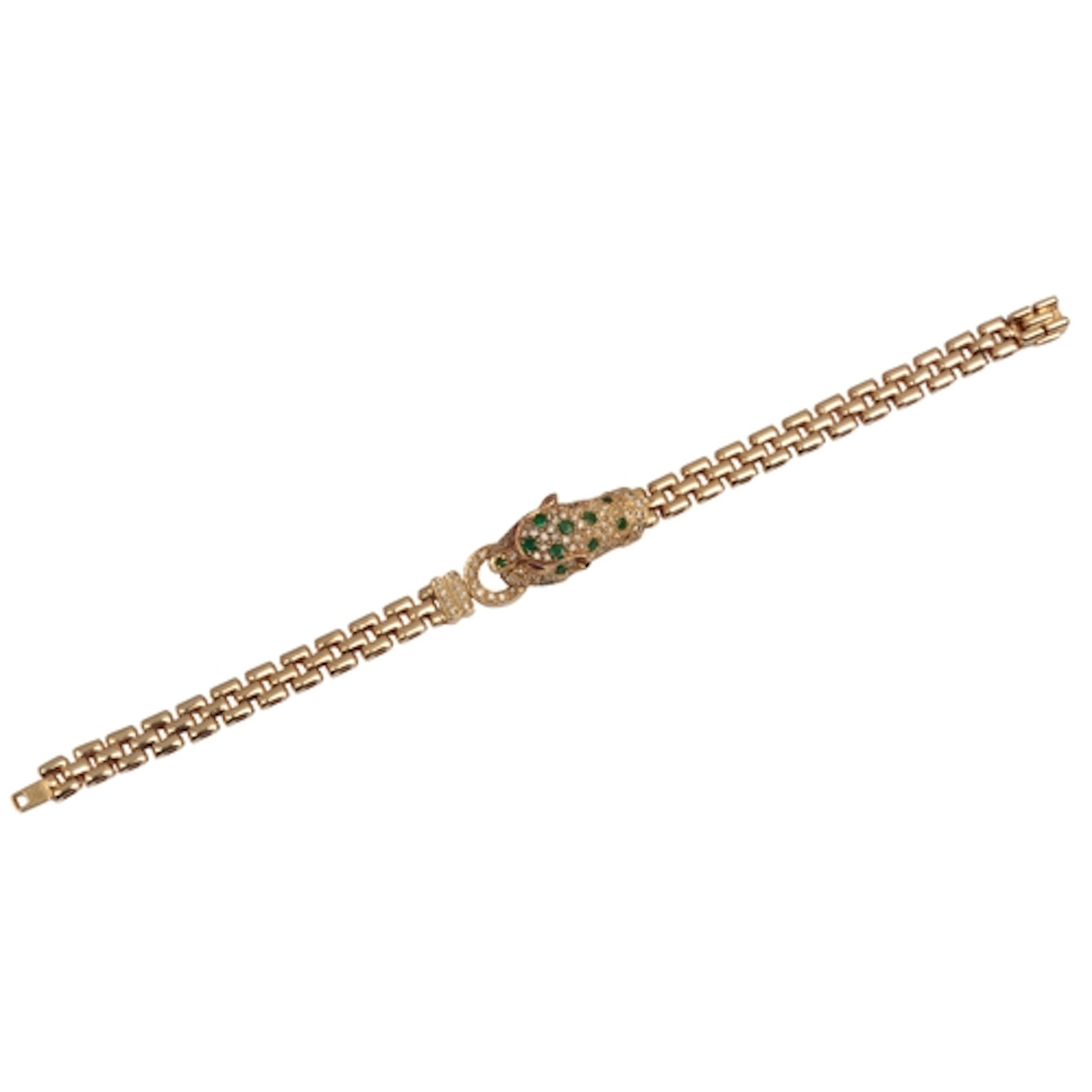 A gold, emerald and diamond bracelet, centring on a panther'...