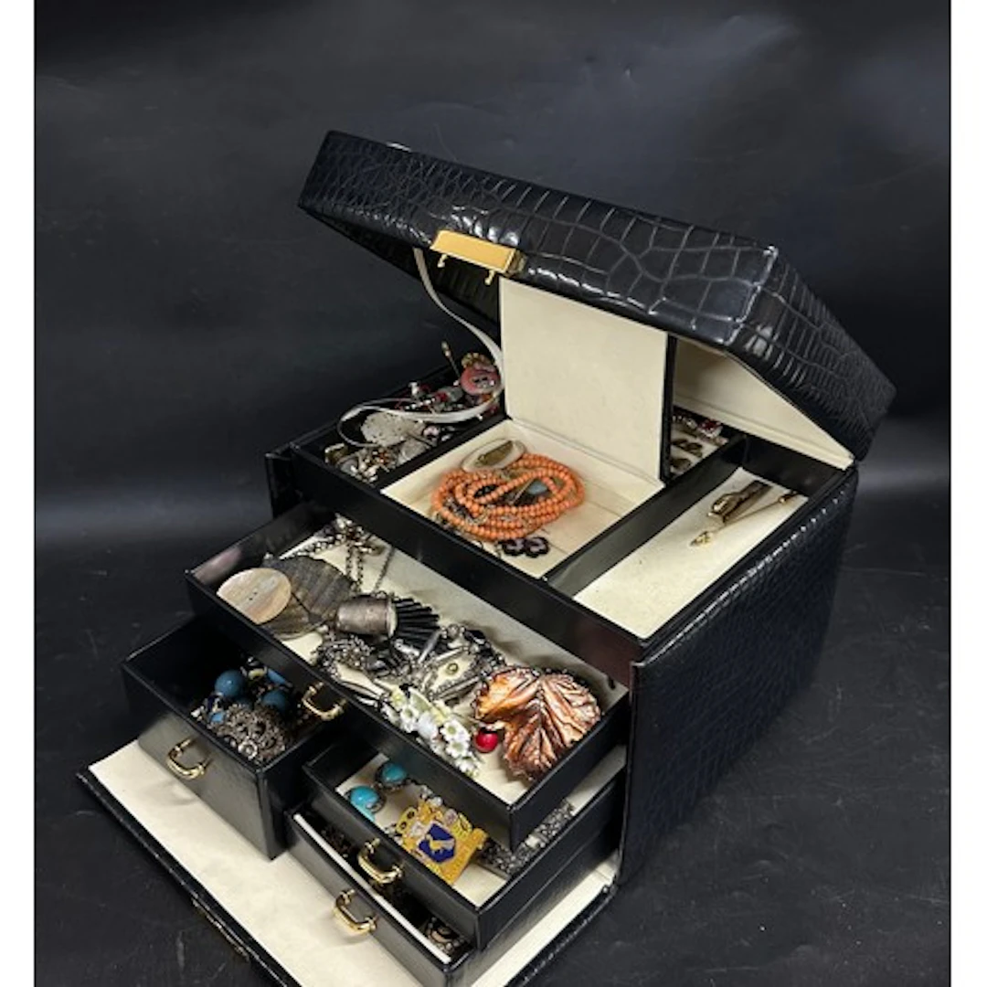 A jewellery case with costume jewellery including rings, ear...