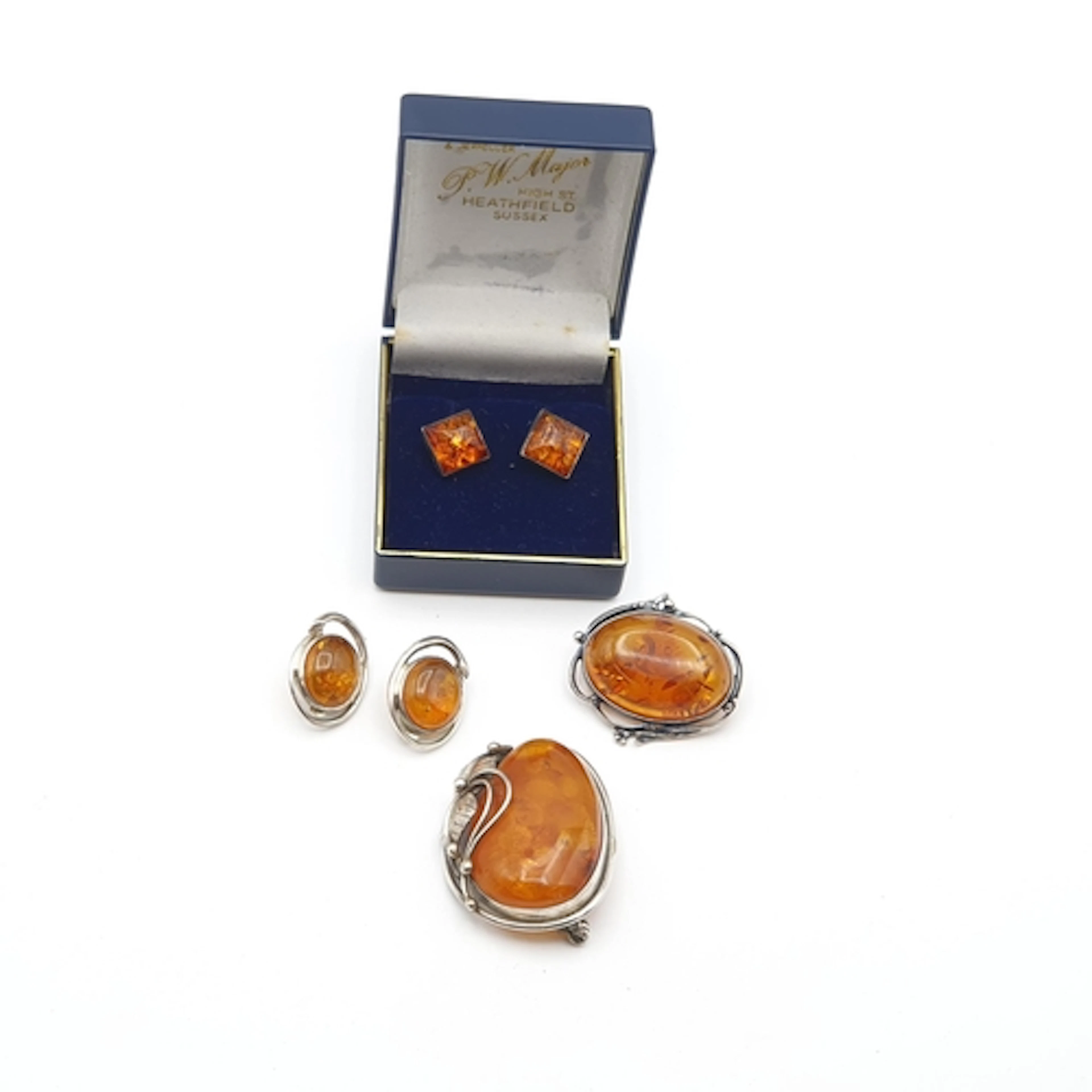 Two modern Amber Brooches in white metal frames, one stamped...