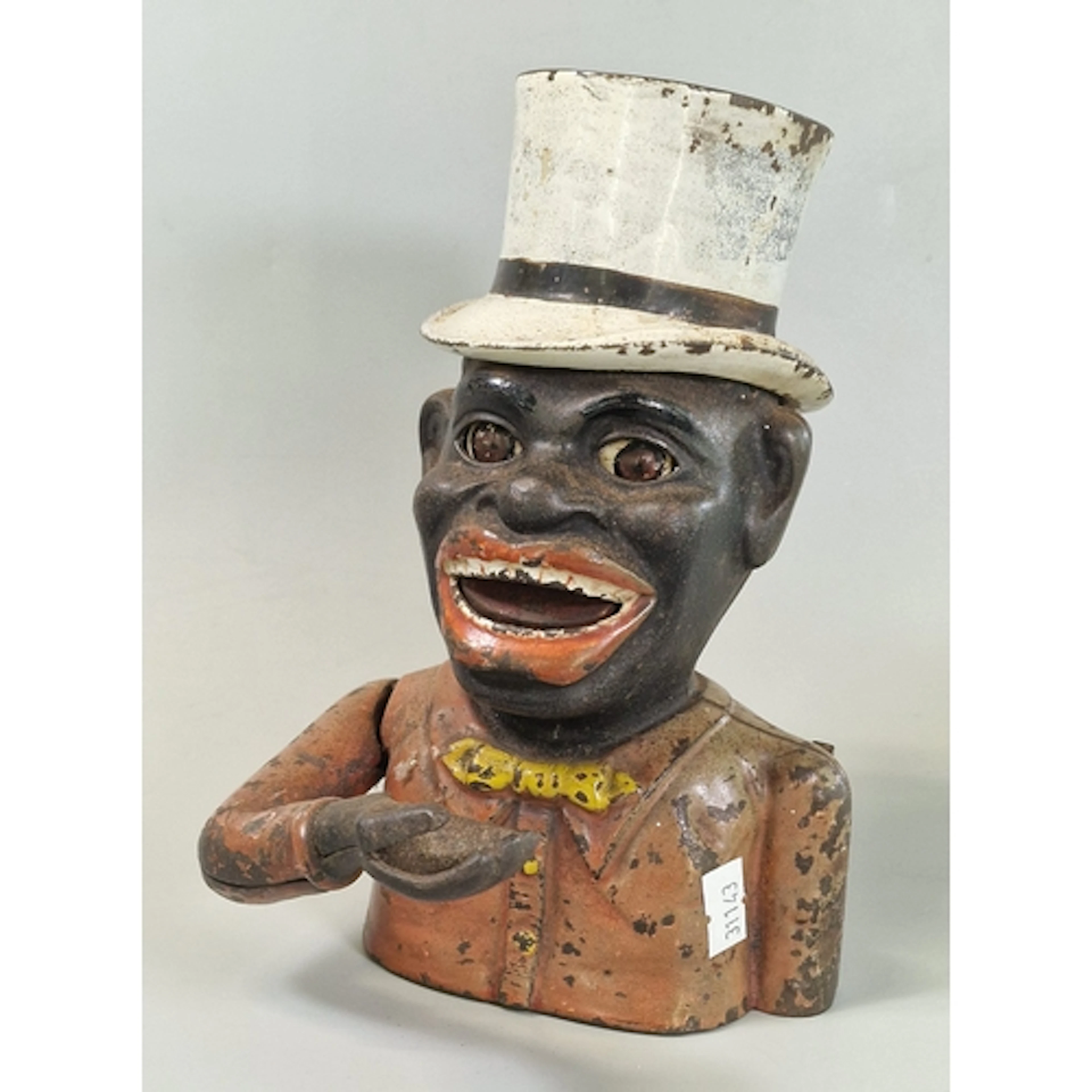 Large cast metal money bank in the form of a top hatted laug...