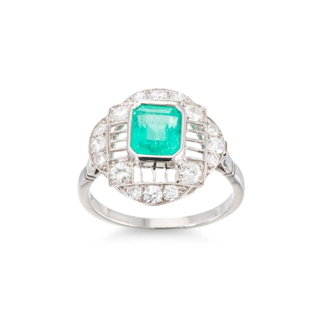 AN ART DECO STYLE EMERALD AND DIAMOND CLUSTER RING, the cent...