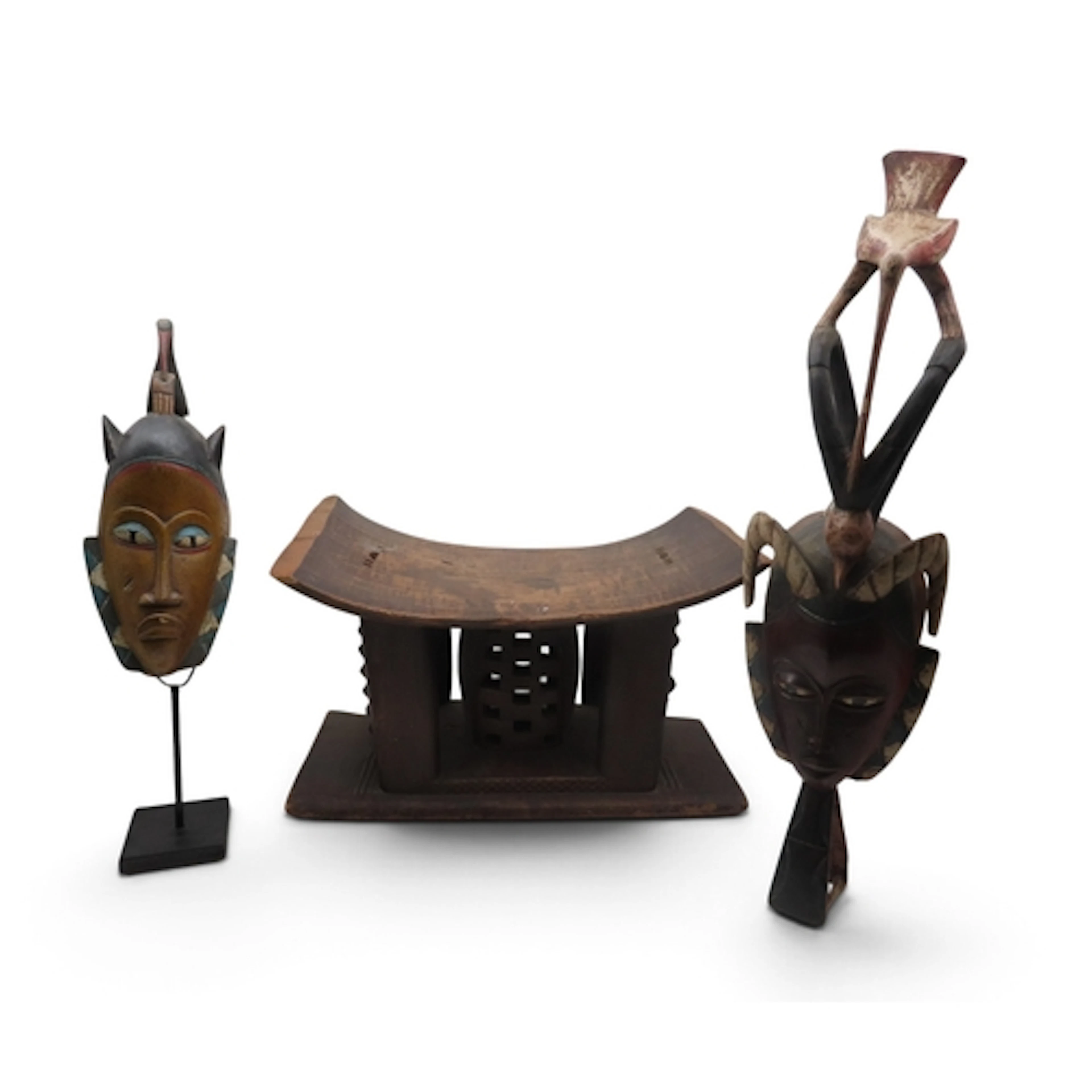 An Ashanti stool, two tribal masks, a blowpipe cane, with wo...