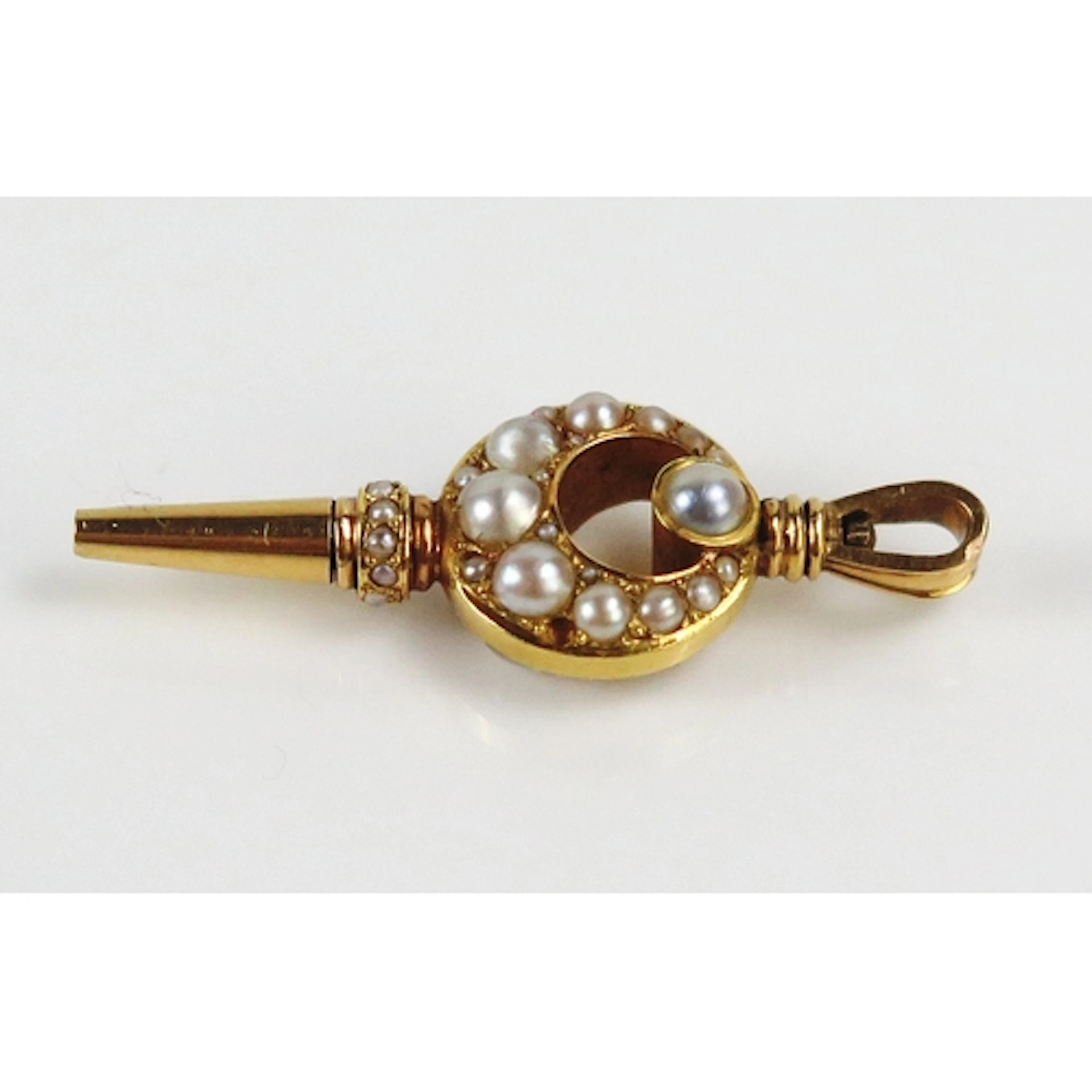 A seed pearl watch key set into a crescent in high carat pre...