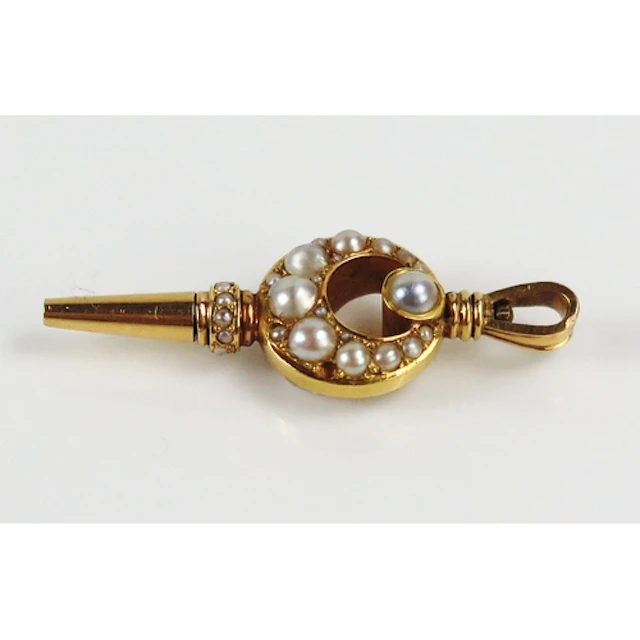 A seed pearl watch key set into a crescent in high carat pre...