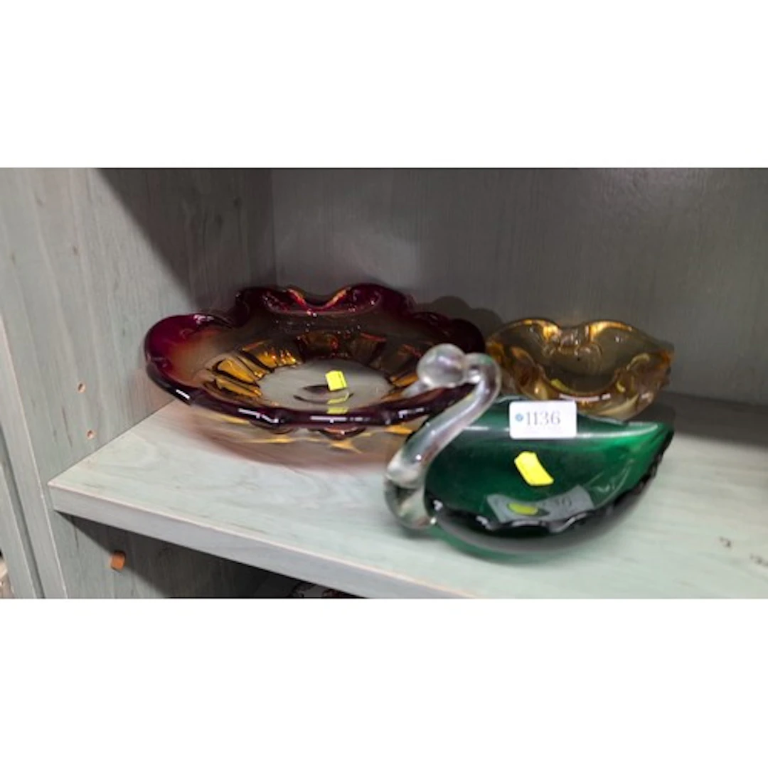 A group of coloured glass dishes comprising a ruby and amber...