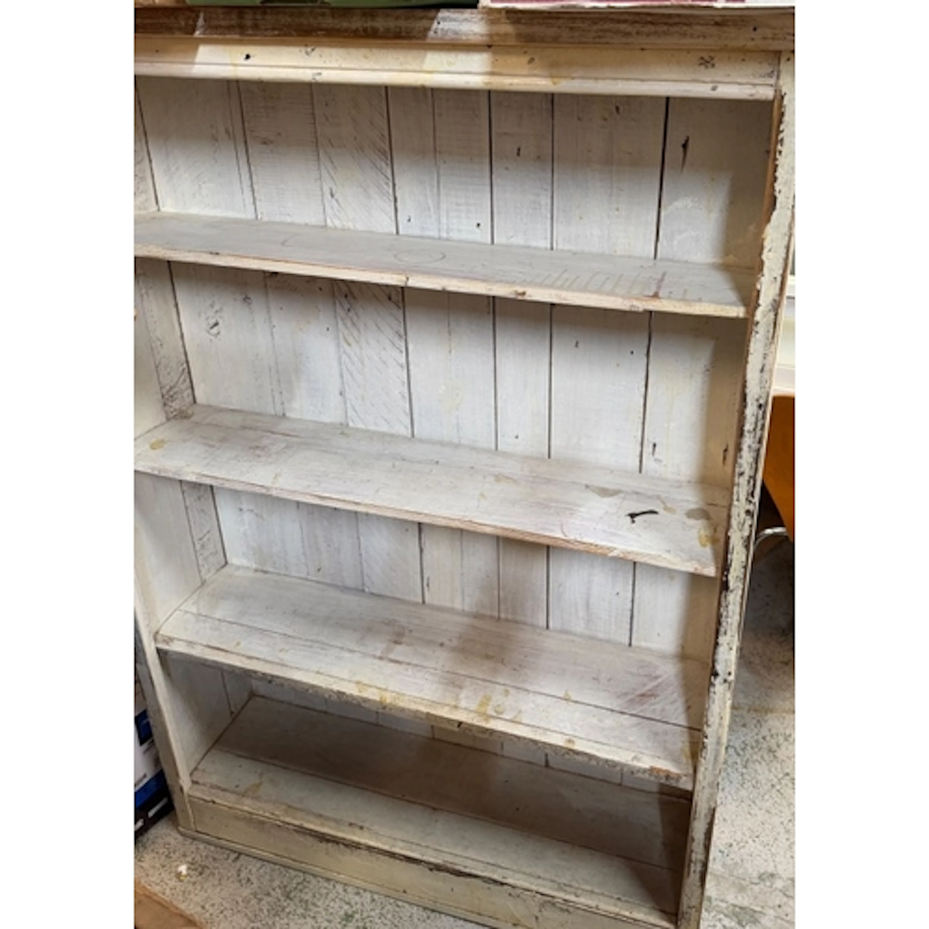 A distressed white painted shelving unit