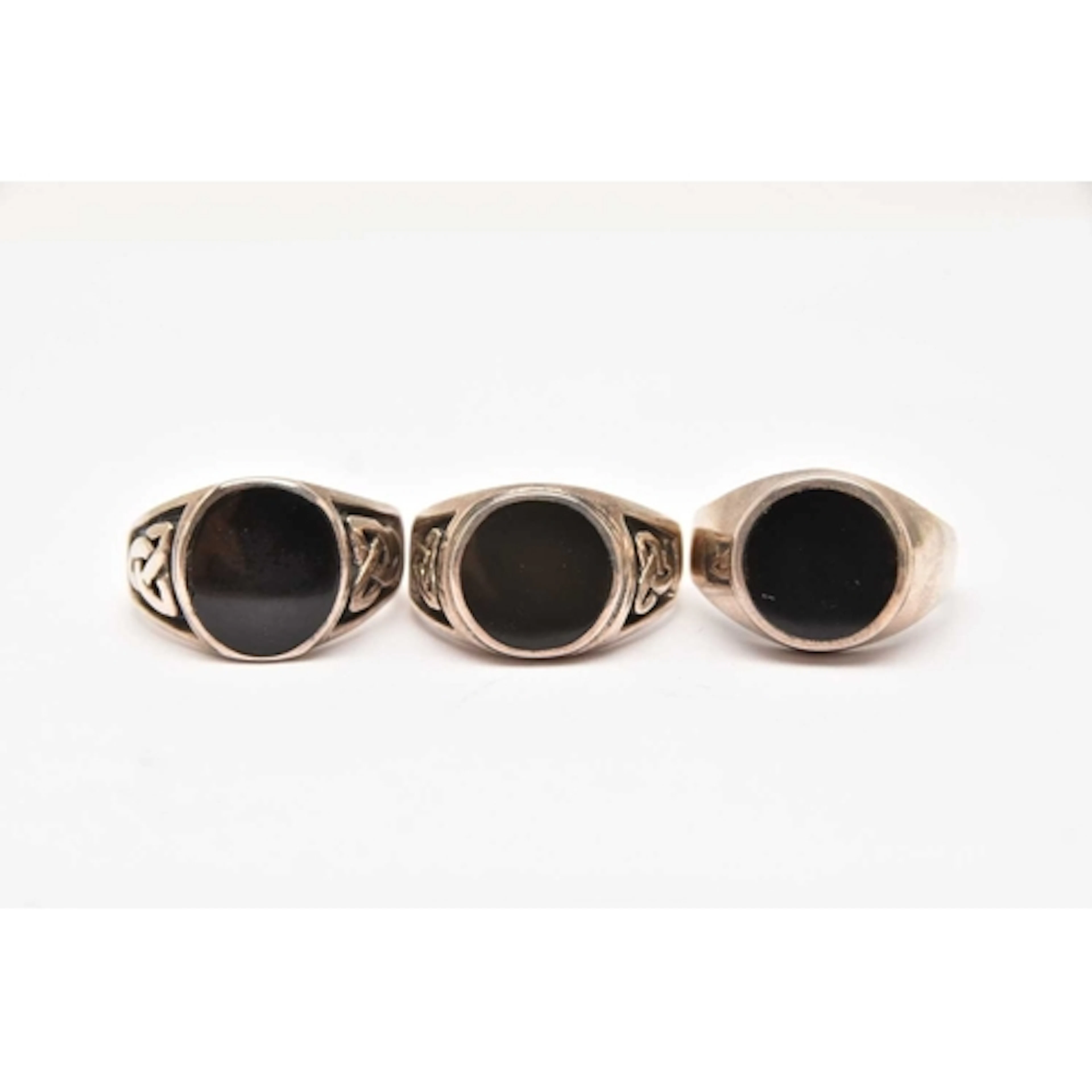 THREE WHITE METAL SIGNET RINGS, each set with onyx, two with...