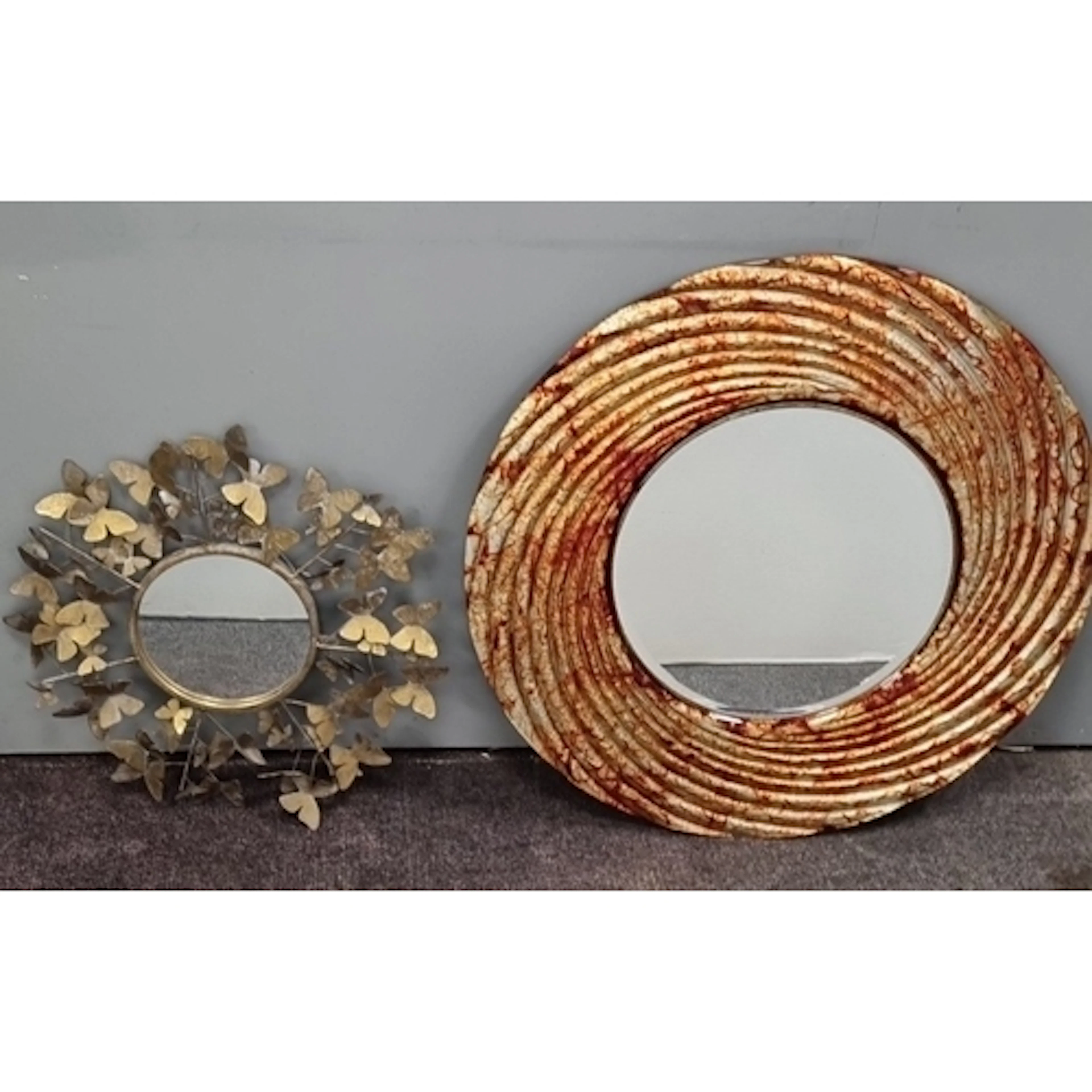 Two contemporary decorative circular wall mirrors, one with...