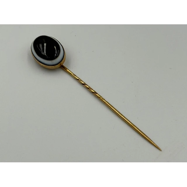 An oval banded agate Victorian stick pin on a gold mount....