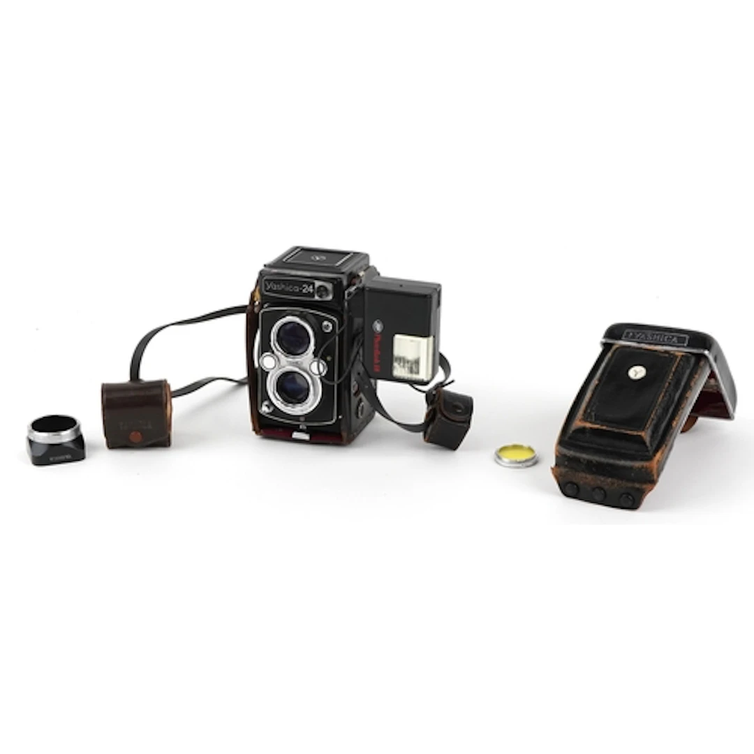 Vintage Yashica 24 camera with leather case and flash unit.