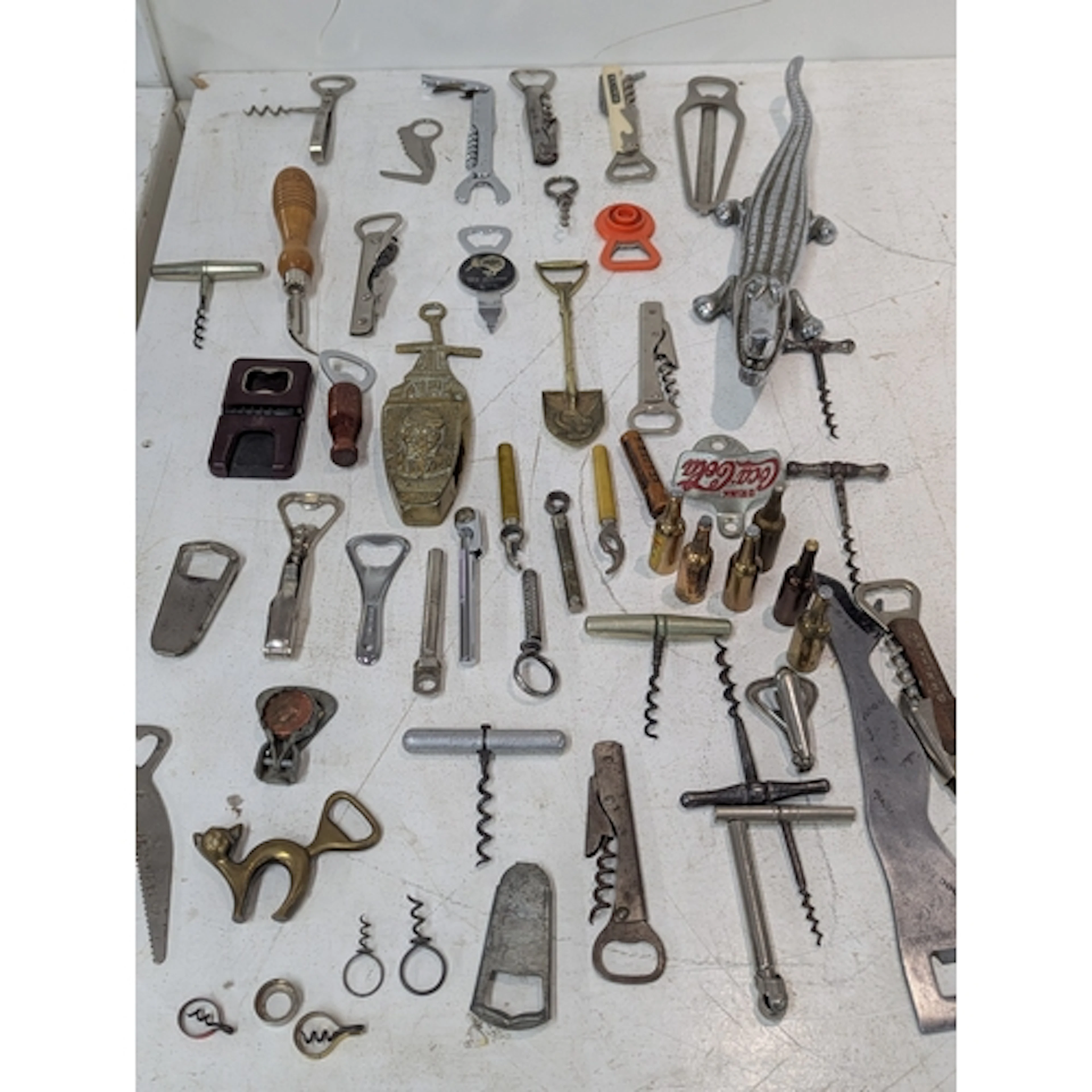 A collection of vintage corkscrews and bottle openers togeth...