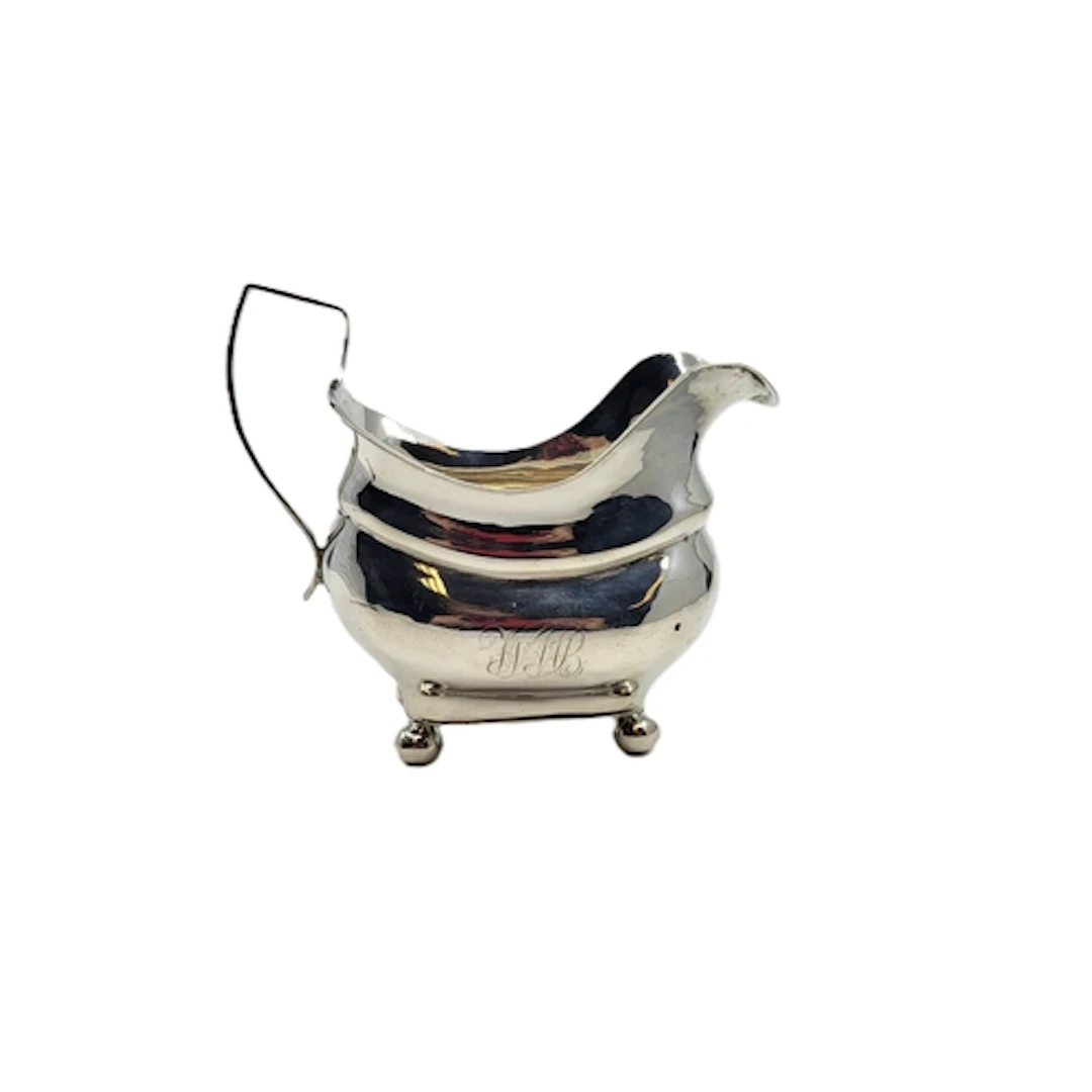 A GEORGE V IRISH SILVER MILK JUG, in loaf of bread from, rai...