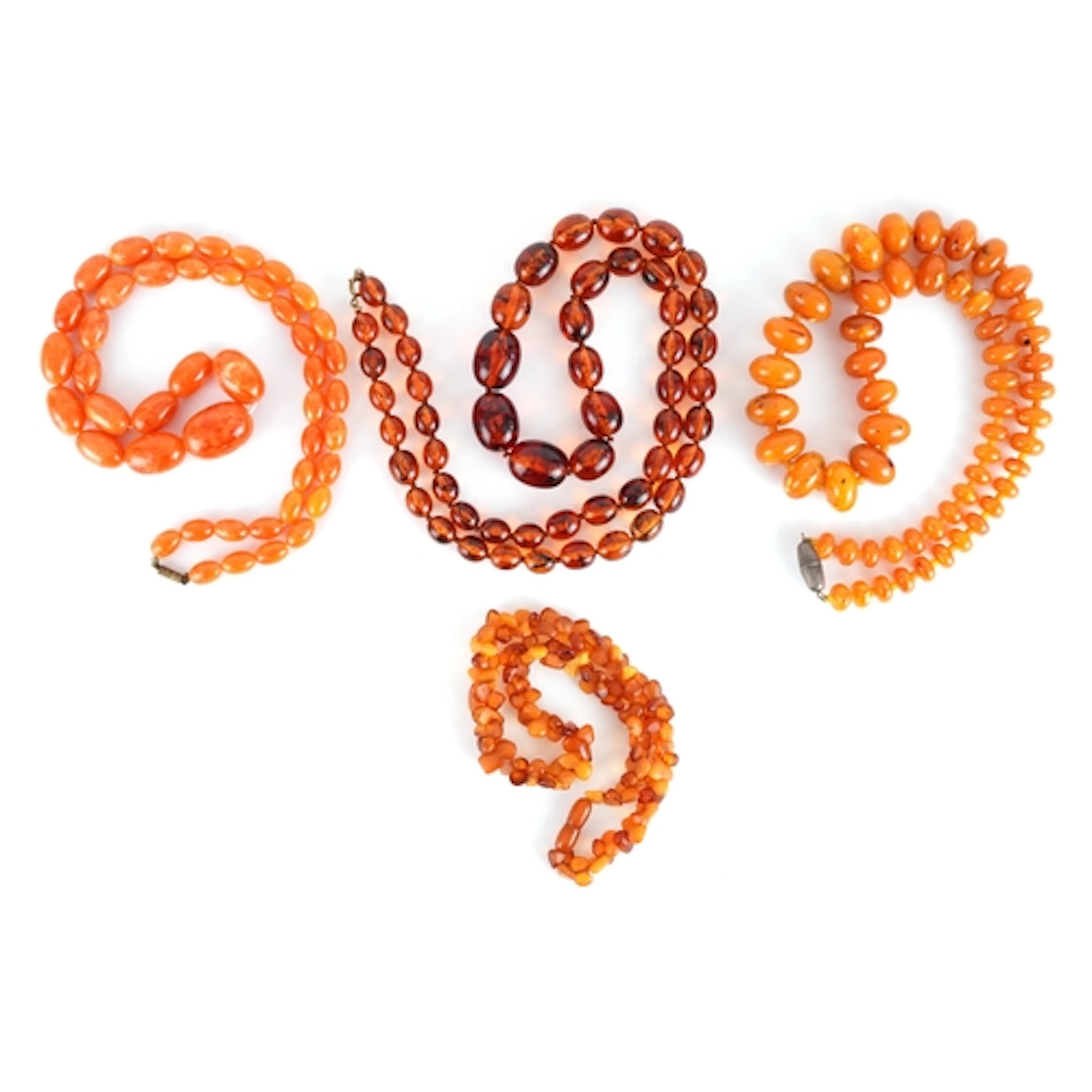 Four amber coloured bead necklaces, the largest 88cm in leng...