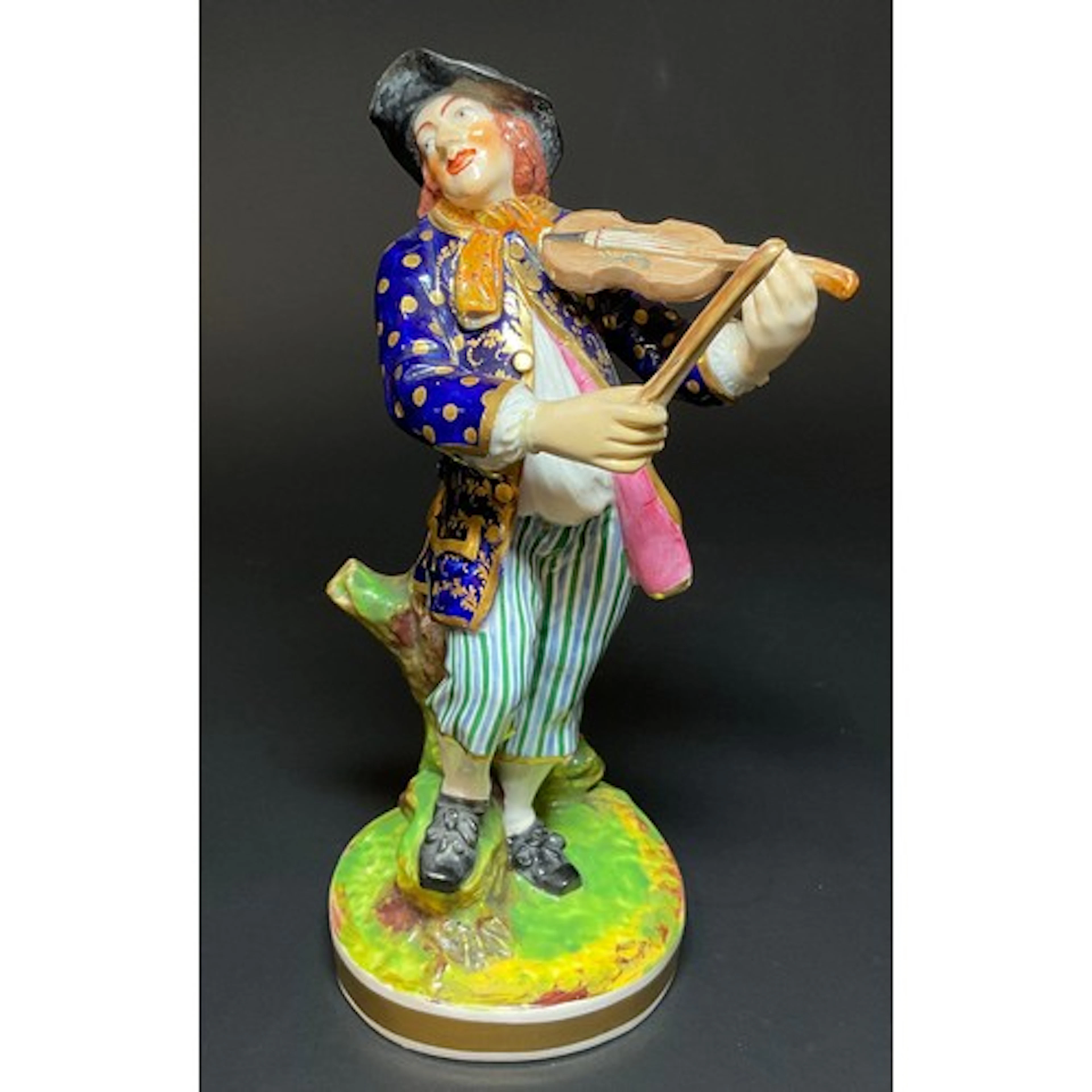 A Derby figure, Male Violinist, he stands wearing gypsy atti...