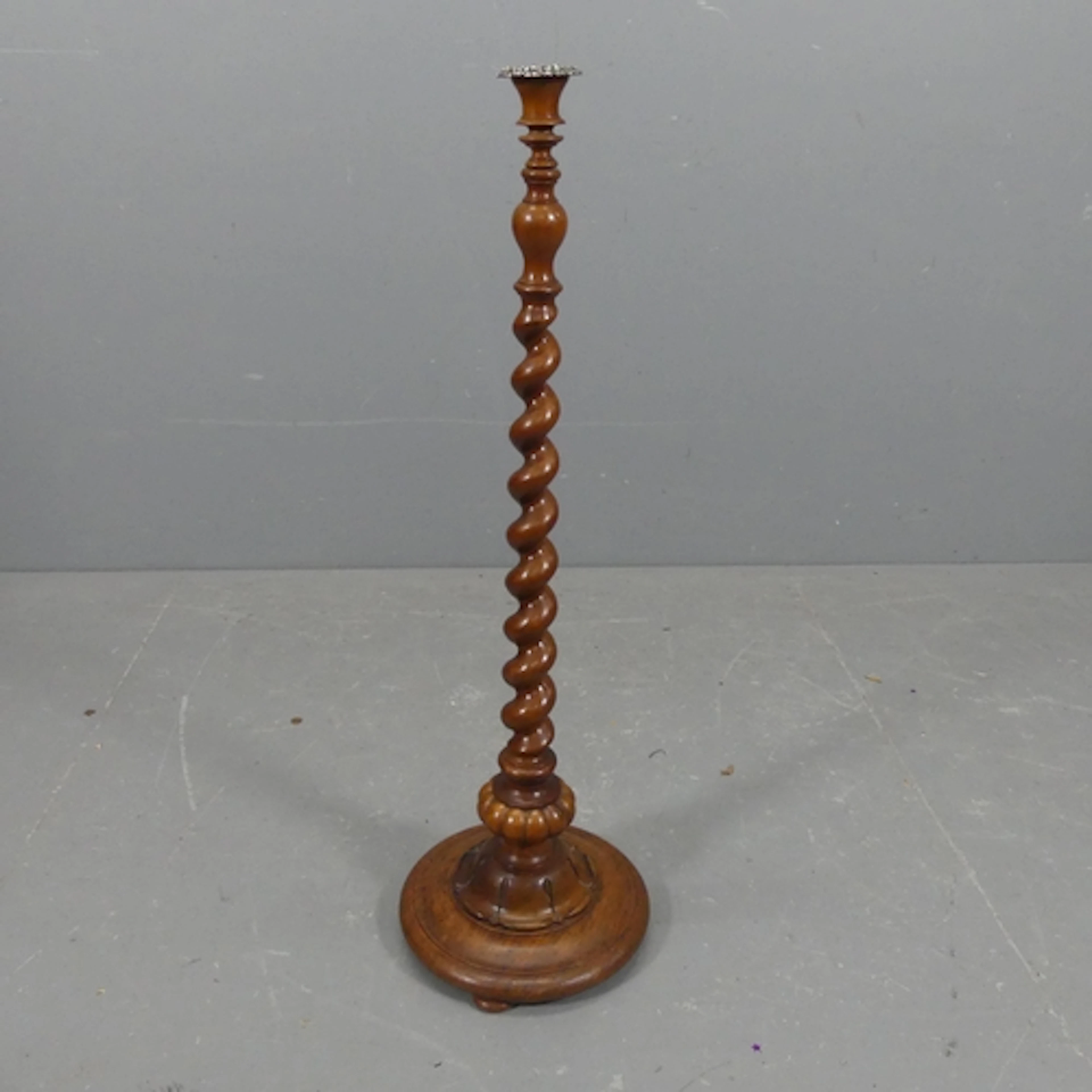 An antique walnut floor standing candle stand, the silver pl...