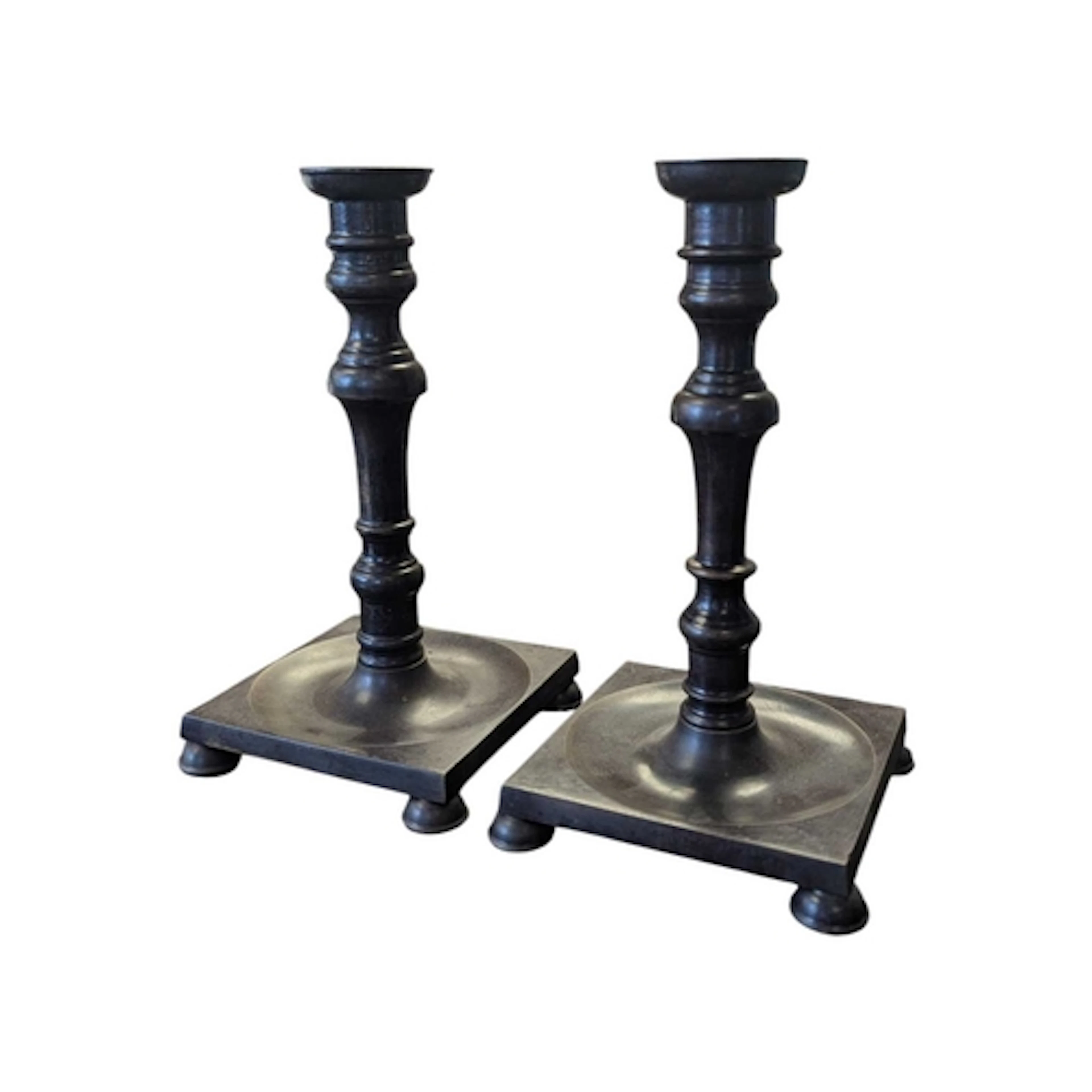 A pair of reproduction cast bronze candlesticks. Each raised...
