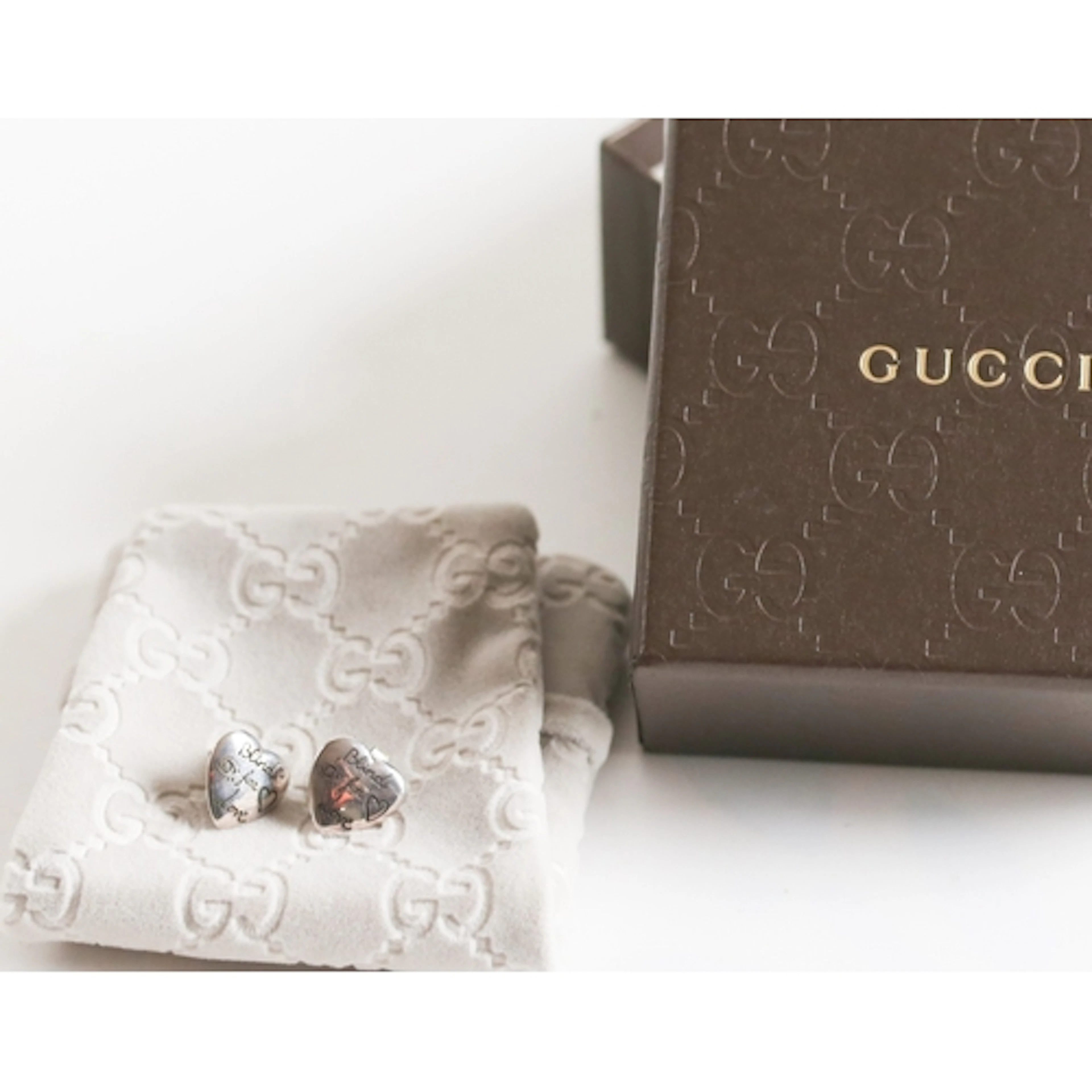 Pair of Gucci Sterling Silver 'Blind for Love' Heart Form Ea...