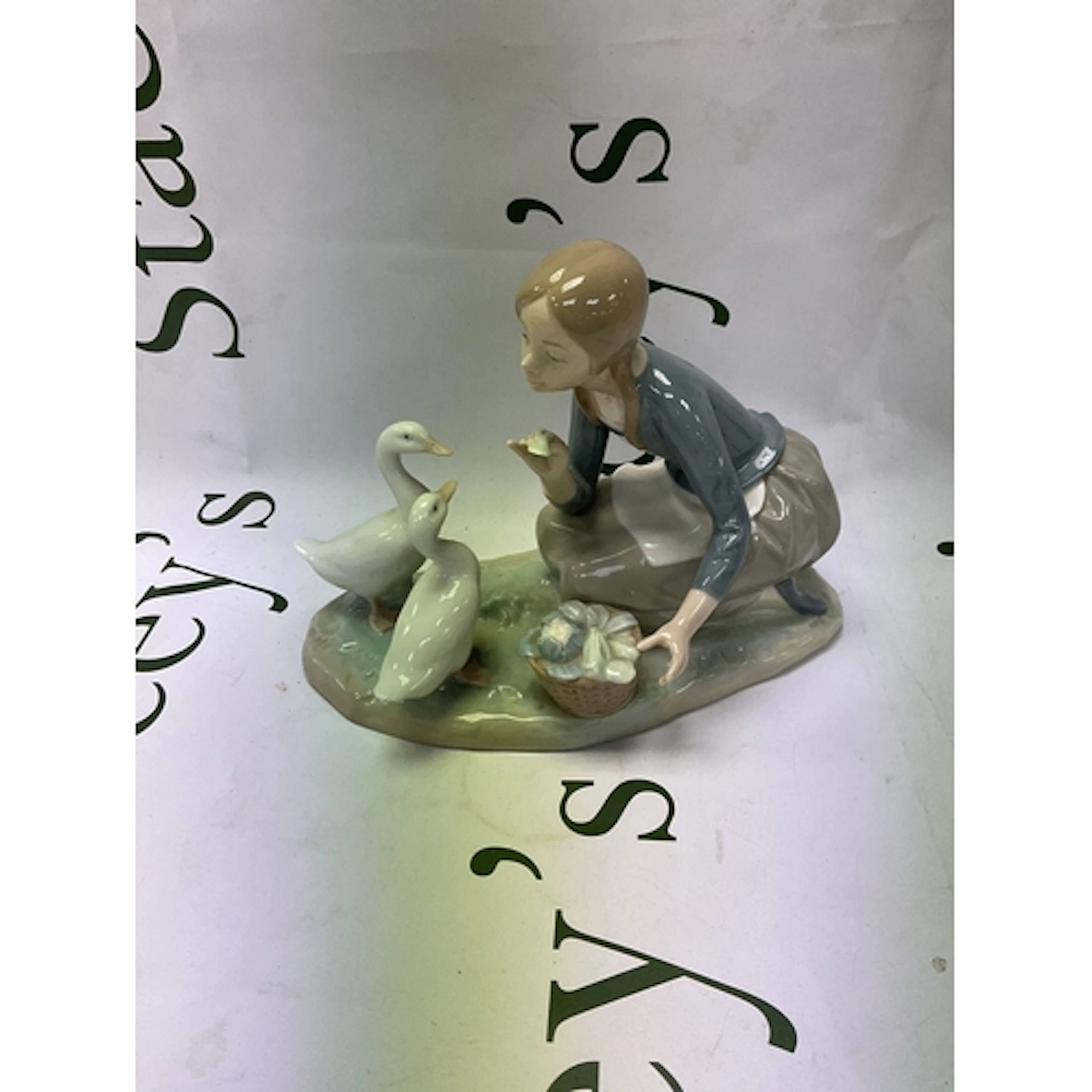 Lladro figurine of a girl feeding ducks.