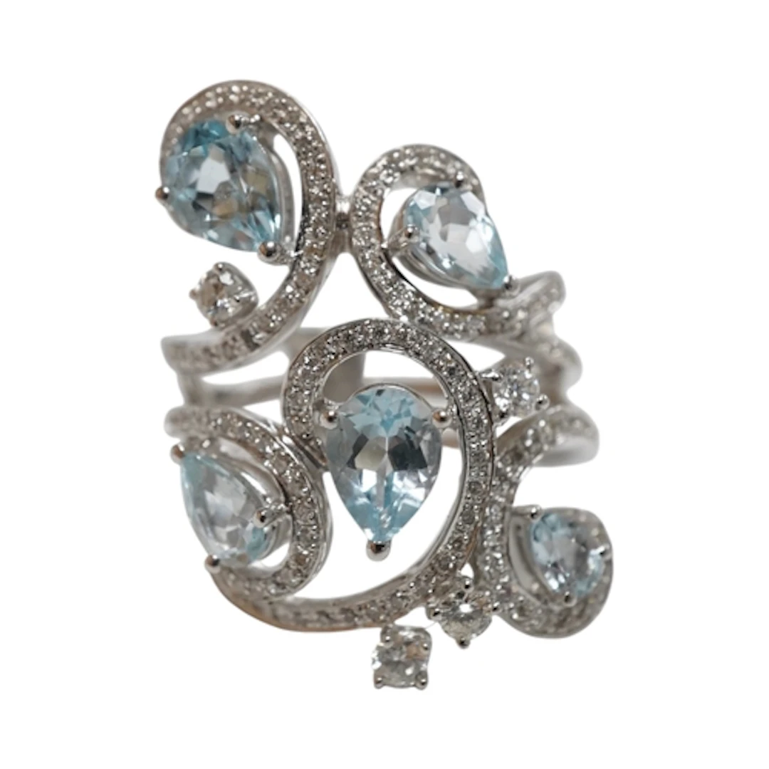 An aquamarine and diamond ring, of foliate scroll design, co...