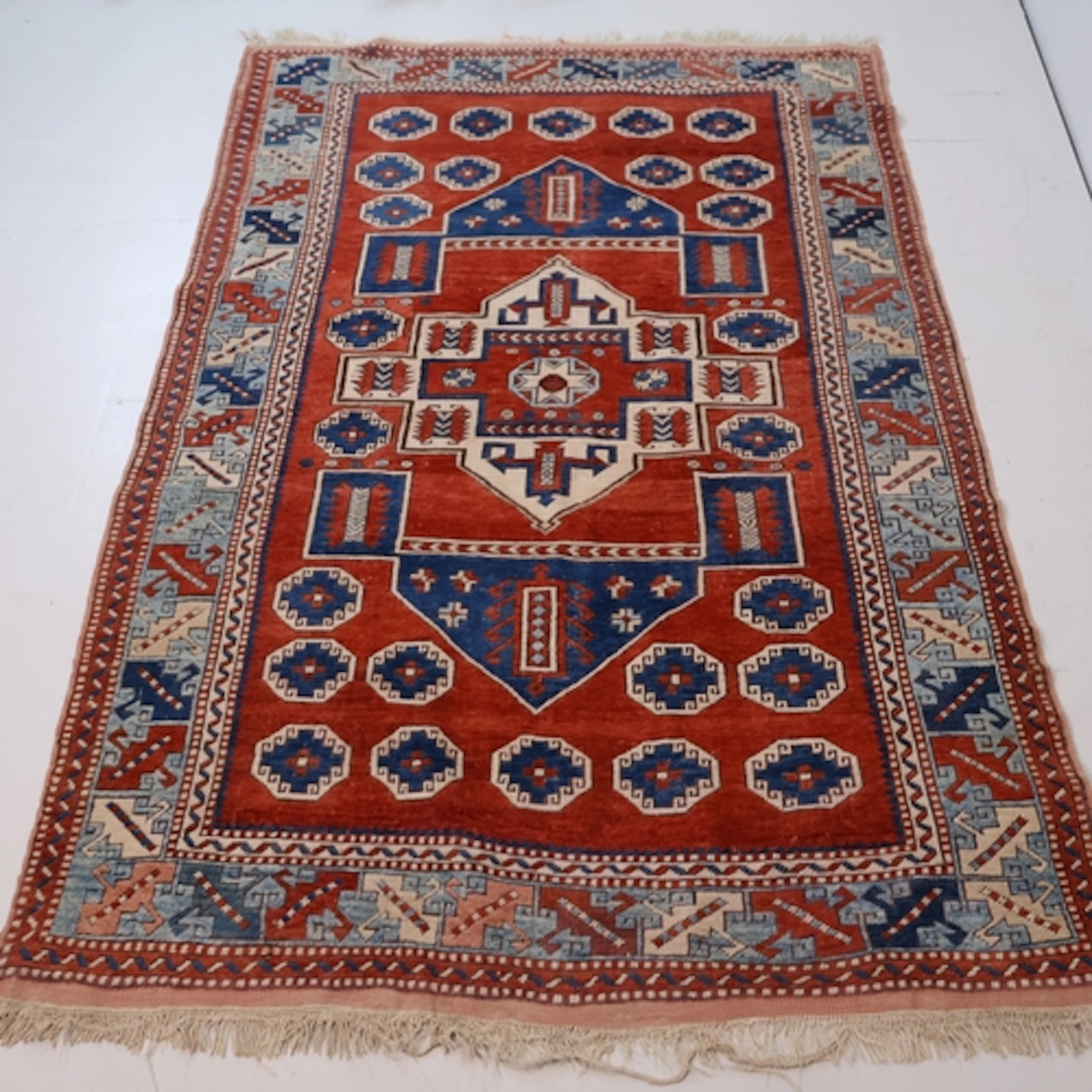 A red ground Caucasian area rug, L221cm, W145cm.